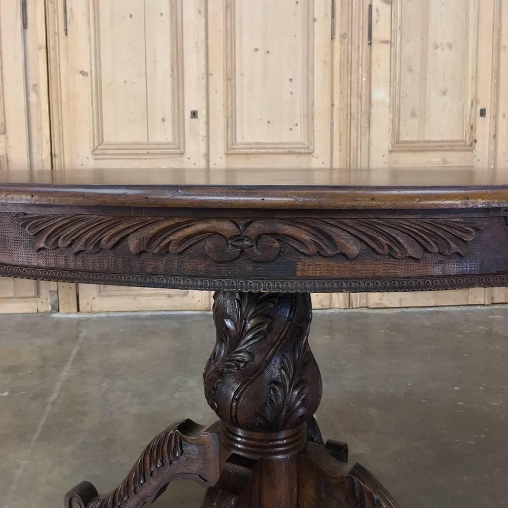 19th century Italian walnut Baroque centre table features a round top with elegantly carved apron supported by a finely carved urn pediment and four graceful hand-carved scrolled legs, all rendered in solid walnut to last for generations, 

circa