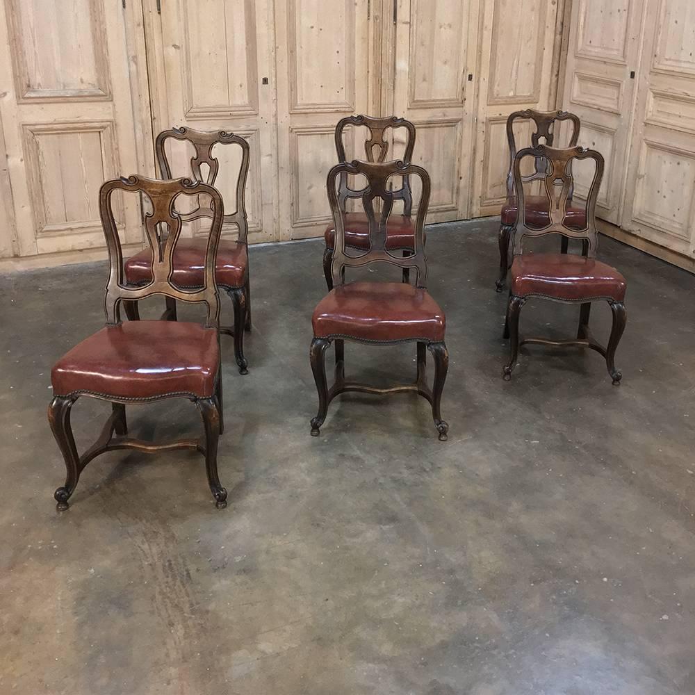 Set of six antique Italian Baroque walnut dining chairs lend an air of formality with their burgundy leather seats and finely contoured frames. Boldly scrolled cabriole legs add a nice touch, all executed in select Italian walnut to last for