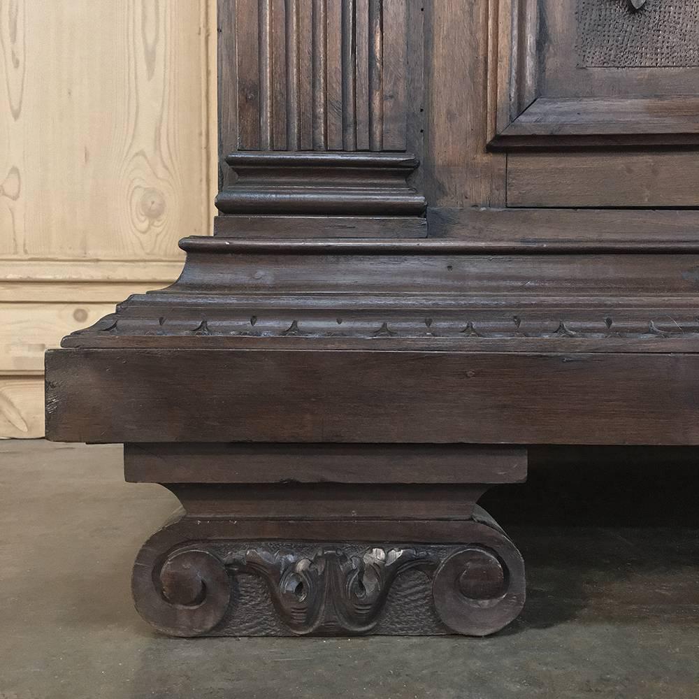 19th century Italian walnut Renaissance buffet was sculpted to perfection in glorious relief across the entire front facade, with carved panels framed by fluted pilasters topped by Corinthian corbels. The drawer tier features acanthus corbels