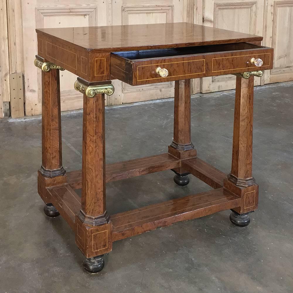 19th century, French Empire inlaid mahogany end table features beautifully figured wood with solid faceted column supports which are adorned with cast bronze ionic capitals above, and bun feet below. The satinwood inlay provides a bordering effect,
