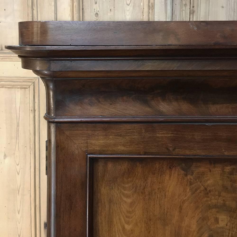 19th century French Louis Philippe mahogany armoire is the epitome of understated elegance, with the lavish natural beauty of the exotic imported mahogany taking center stage amongst the tailored molding details from the crown to the base. Doors