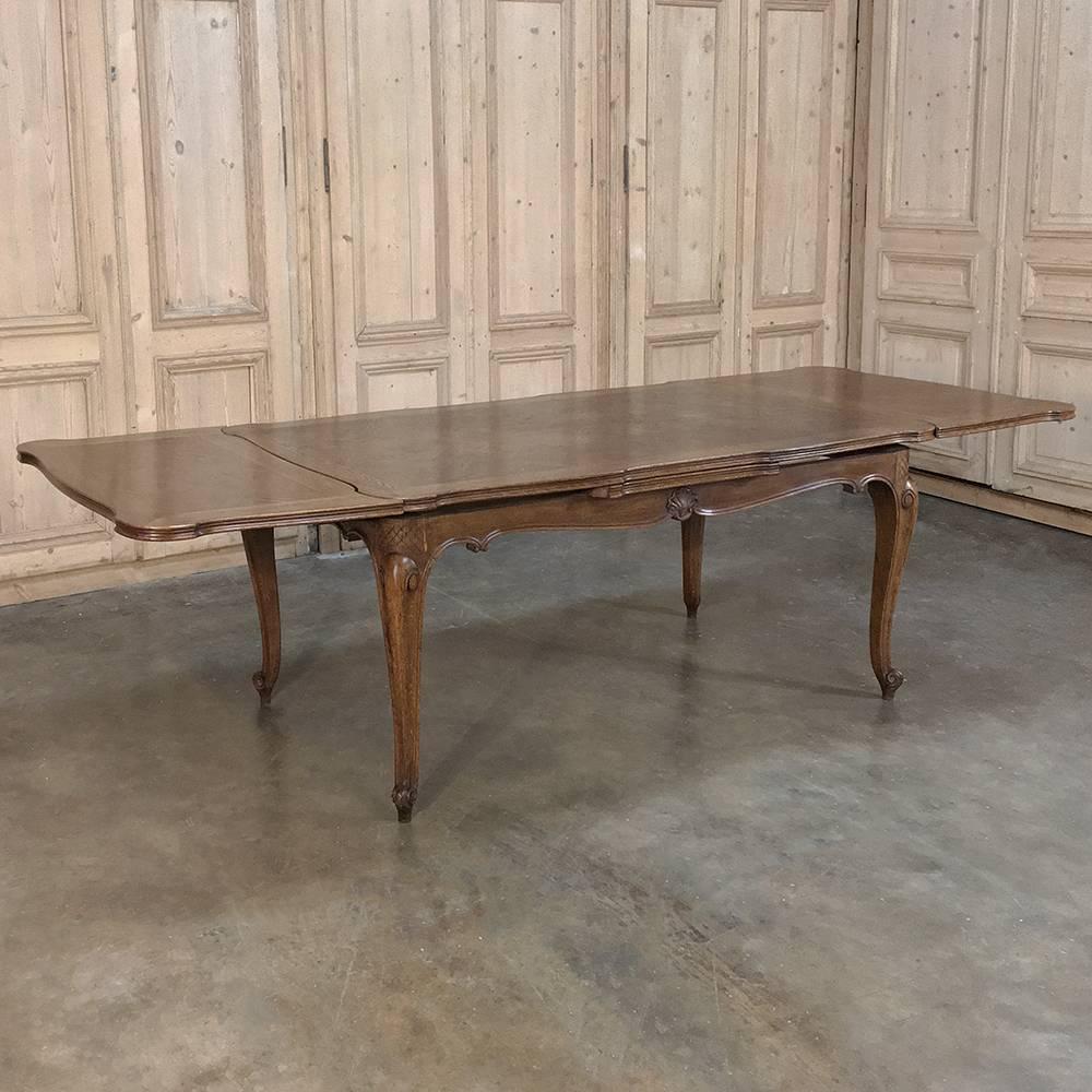 Antique Country French draw-leaf dining table was lovingly handcrafted from old growth quarter-sawn oak, then contoured and carved with a level of craftsmanship and artistry that is rarely seen today! Four subtly scrolled cabriole legs support the