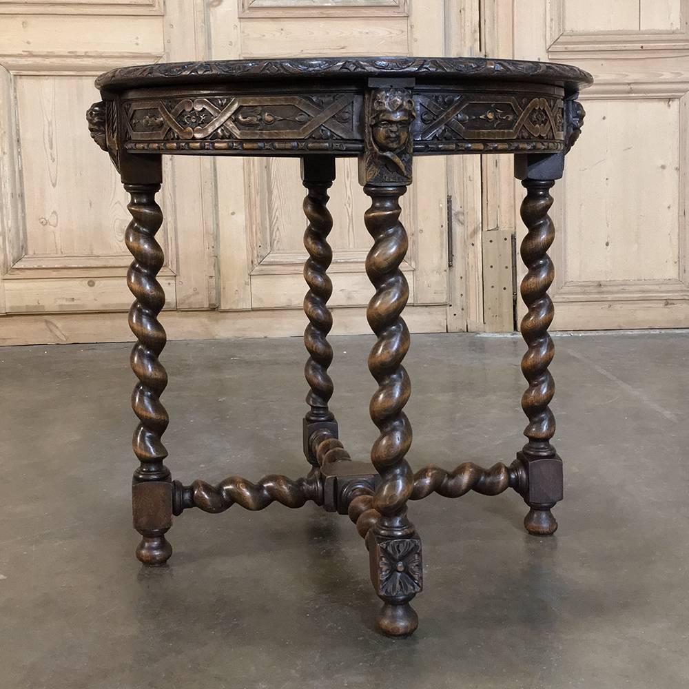 19th century round Renaissance lamp table with cherubs was sculpted from solid oak, and feature intricately carved aprons between the charming cherubs' faces appearing atop each of the four barley twist column legs, themselves reinforced and adorned