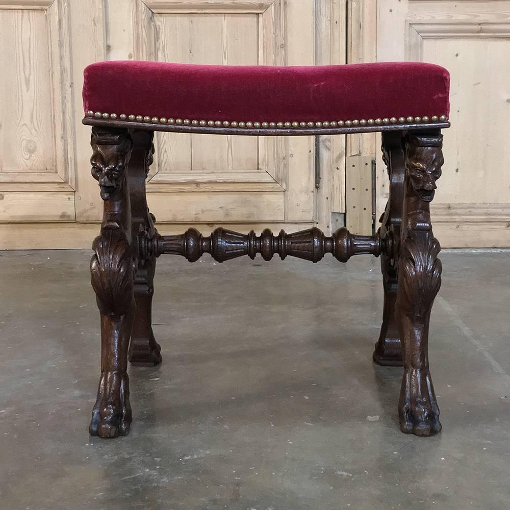 19th century, Renaissance footstool with velvet and carved gryffins is ideal for the masculine decor, and features artistic sculptures of the fearsome mythical beast that was a cross between a horse and a dragon, to oversimplify. Four hand-sculpted