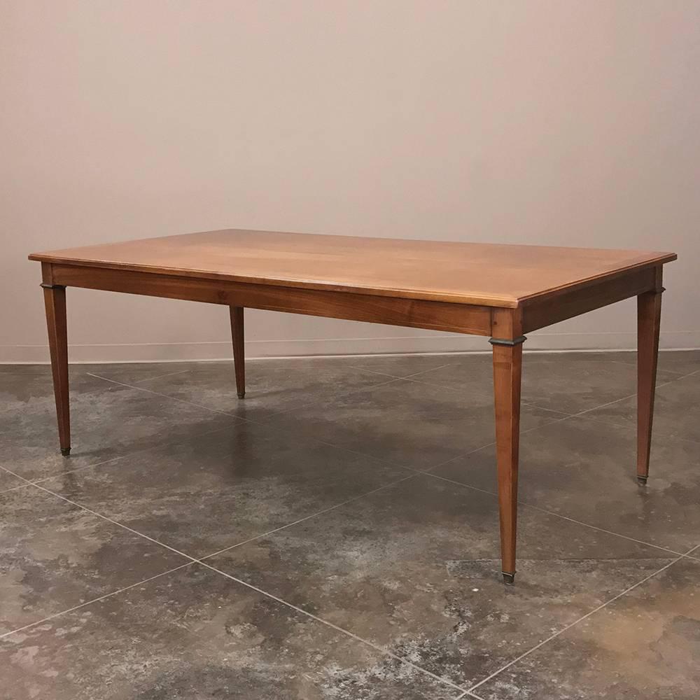 This 19th century French Directoire cherrywood dining table has stately, clean lines and glorifies the natural beauty of the wood to make an excellent selection for most any variety of decor. Brass accents add a touch of elegance. Comfortably seats