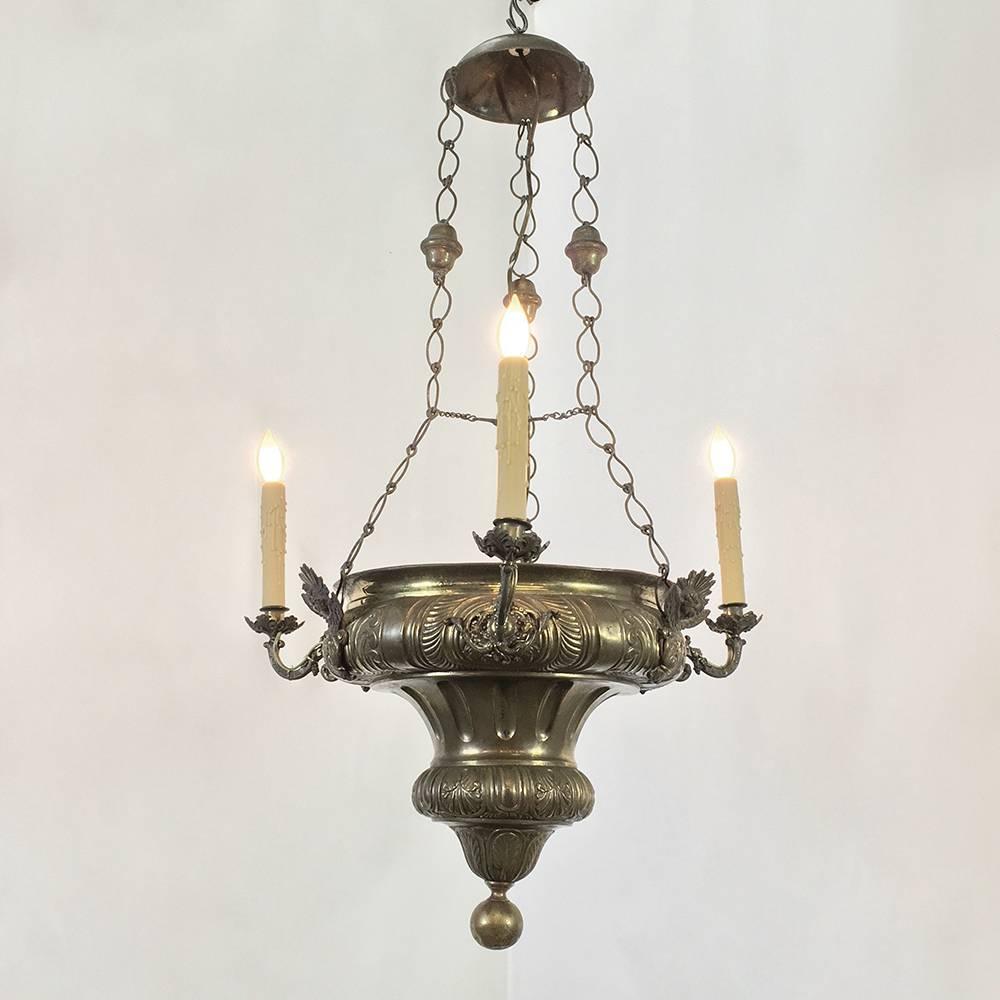 19th century embossed brass Gothic church chandelier was originally designed for four candles around the outside, with a place to put incense on the inside to help keep a pleasant scent during services. This example features styling that is somewhat