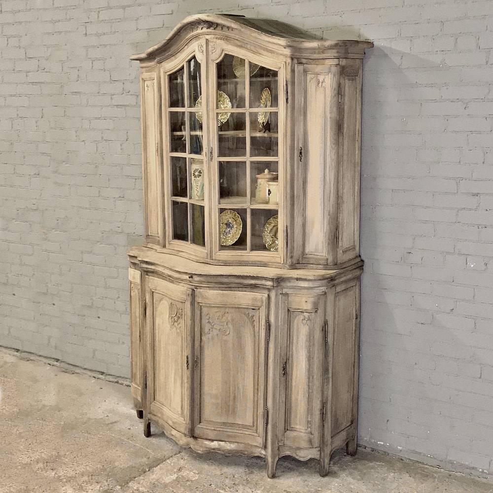 19th century Dutch oak bookcase -vitrine was handcrafted by master artisans from indigenous old-growth quarter-sawn oak, and features a boldly arched crown combined with a bow front shape that is not only visually appealing, but also very traffic