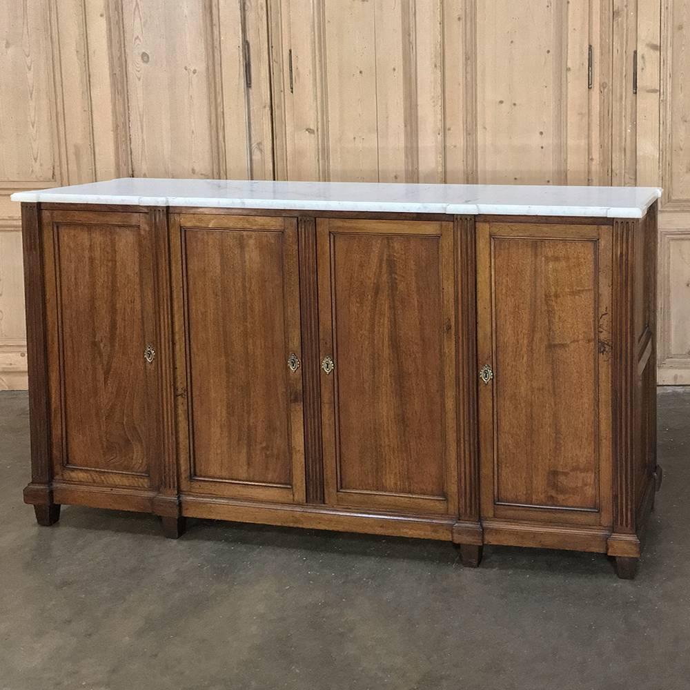 19th century French Directoire marble top mahogany buffet is the essence of the tailored look, emphasizing the sheer natural beauty of the exotic imported mahogany as well as the timeless look of the white Carrara marble top. Four spacious cabinets