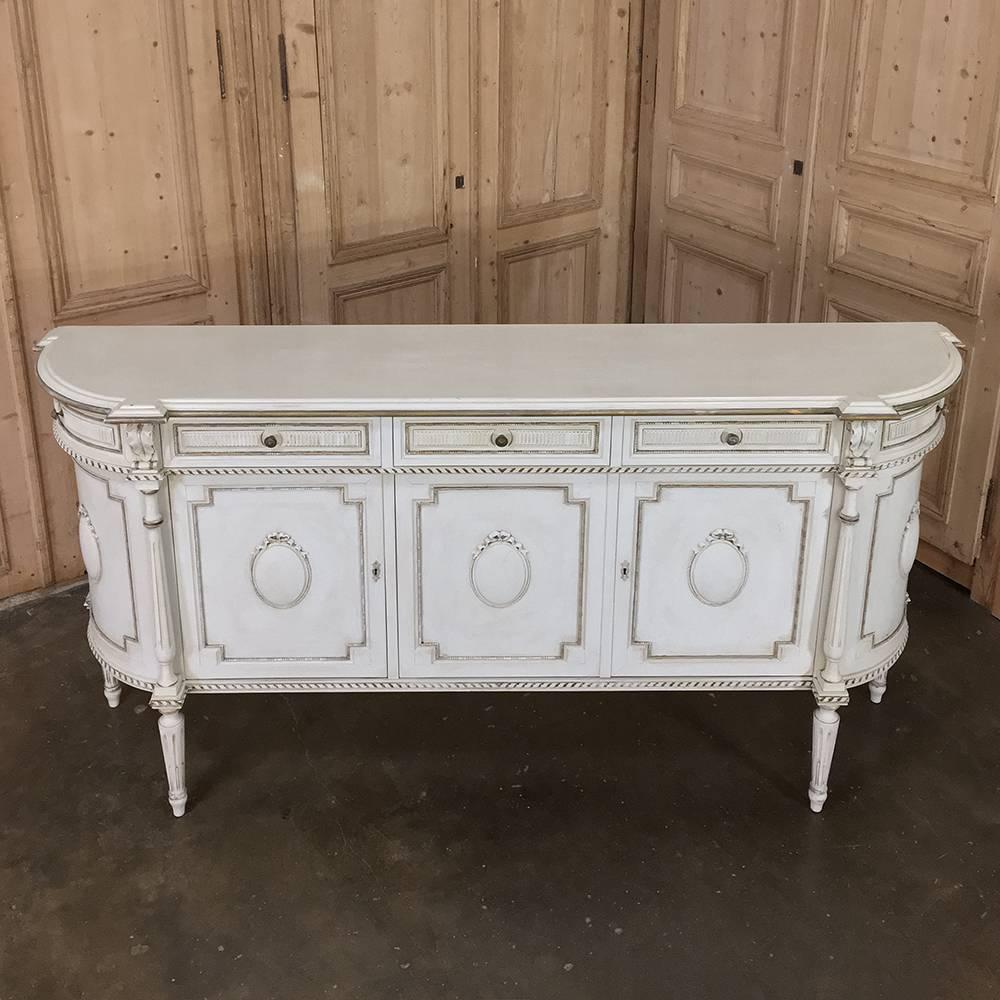 Antique Italian painted Louis XVI buffet is a wonderful neoclassical design that includes rounded side cabinets, three doors and three drawers across the main facade, all raised on tapered & fluted legs for a timeless look. The painted finish has