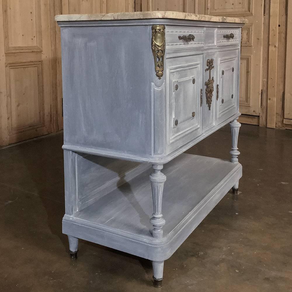 19th century French Louis XVI marble-top painted buffet features its original luxurious beveled marble top resting on hand-carved sumptuous French walnut with a display shelf below! The painted finish features a patina that complements the original