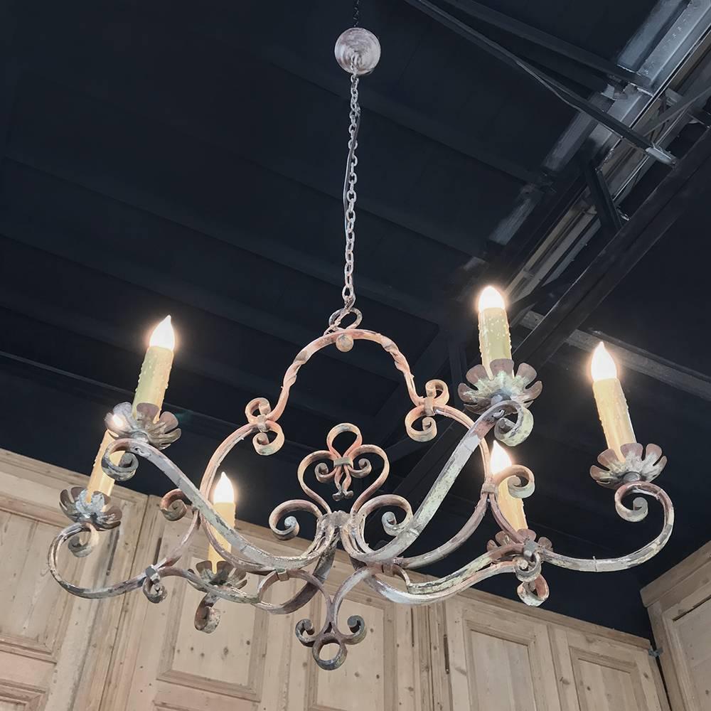 Antique Country French wrought iron painted chandelier is a light and airy design with elegant scrollwork, and a painted finish that has achieved a lovely patina over the intervening decades! Standard electrification with medium base sockets is