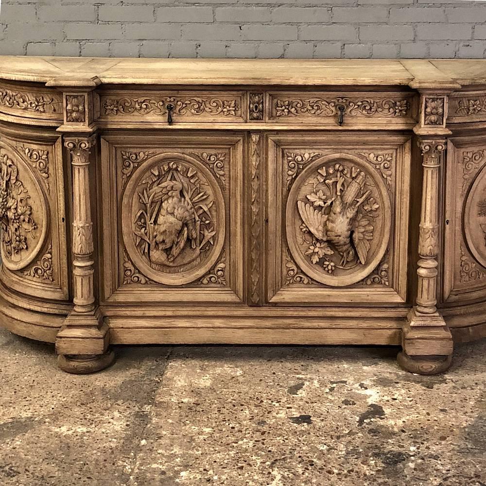 19th century, French Renaissance stripped oak buffet is a wonder to behold, with sculptures appearing on all four cabinet doors, including the rounded side doors! Each sculpture is meticulously hand-carved to depict the wheat harvest on the right,