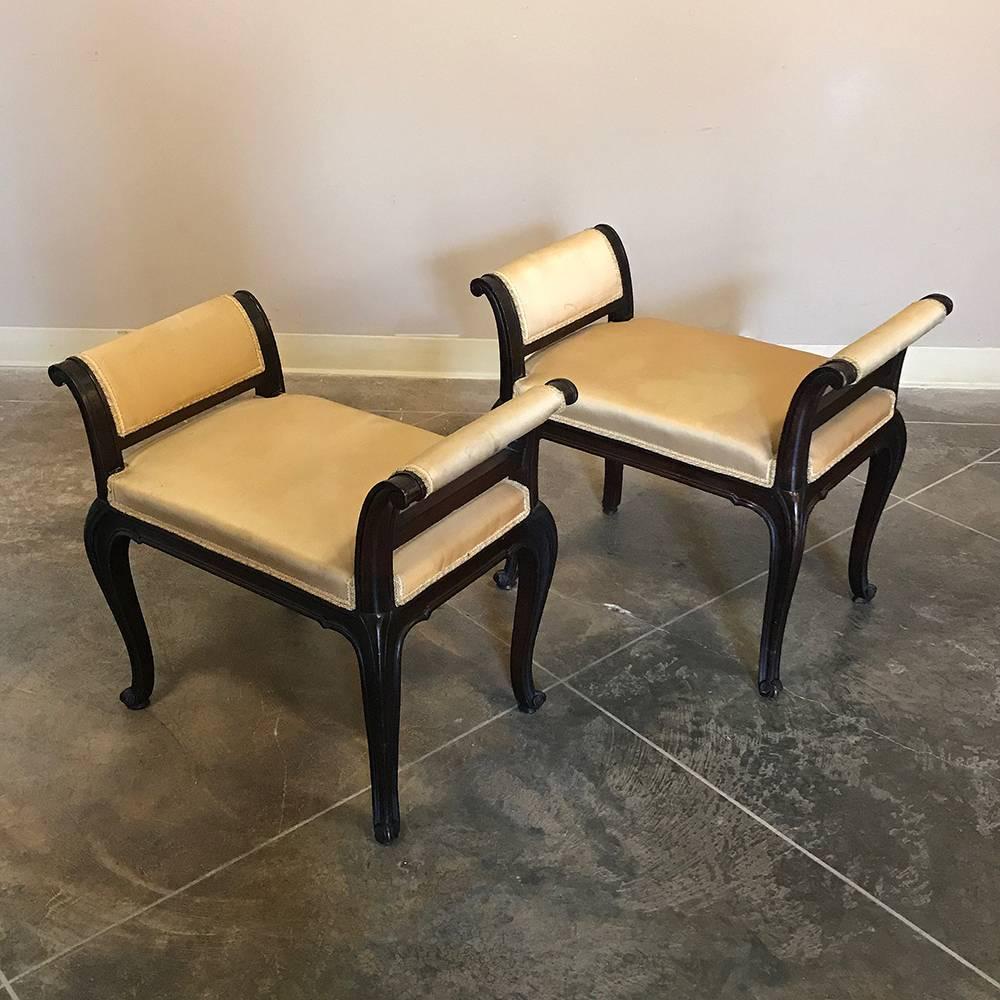 Pair of antique Italian walnut arm benches are perfect for living room,  bath, bedroom, or even as footstools! Hand-sculpted in elegant Rococo style from solid walnut, their original upholstery in brushed silk is in very serviceable condition yet
