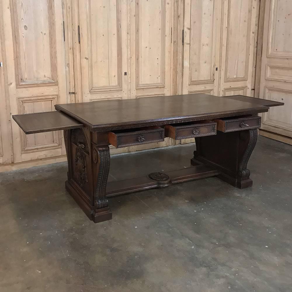 19th century Italian Renaissance hand carved oak desk has a decidedly Tuscan feel, yet harkens back to the design exuberance of the Renaissance, with bold scrolled leg supports on each end connected with a full width stretcher (which makes a great