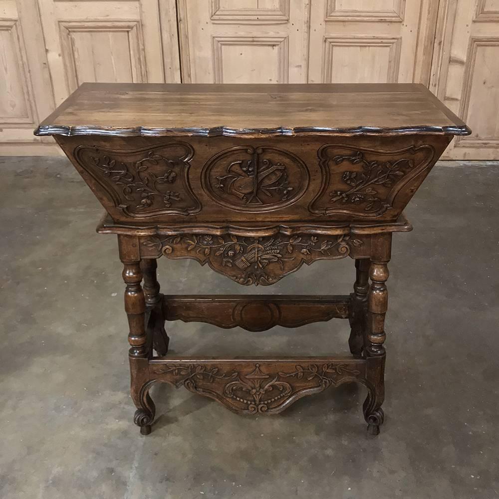 19th century country French walnut petrin - doughbox is a marvel of handcrafted excellence, rendered in sumptuous hand-picked French walnut for timeless enjoyment! The joys of life are sculpted in relief on the facade representing music and bounty
