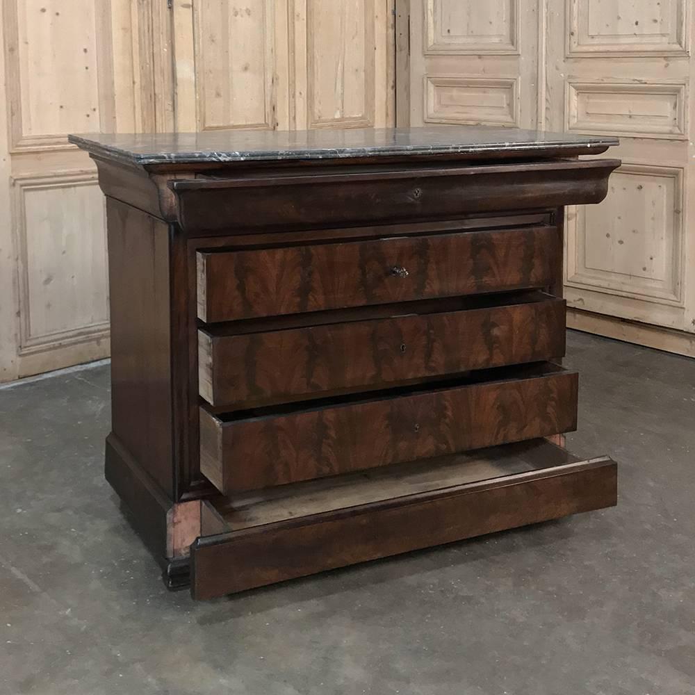 19th century French Louis Philippe period mahogany marble-top commode is a classic example of the genre, eschewing carved or bronze-mounted ornamentation to produce a tailored, clean look that accentuates the sheer natural beauty of the exotic
