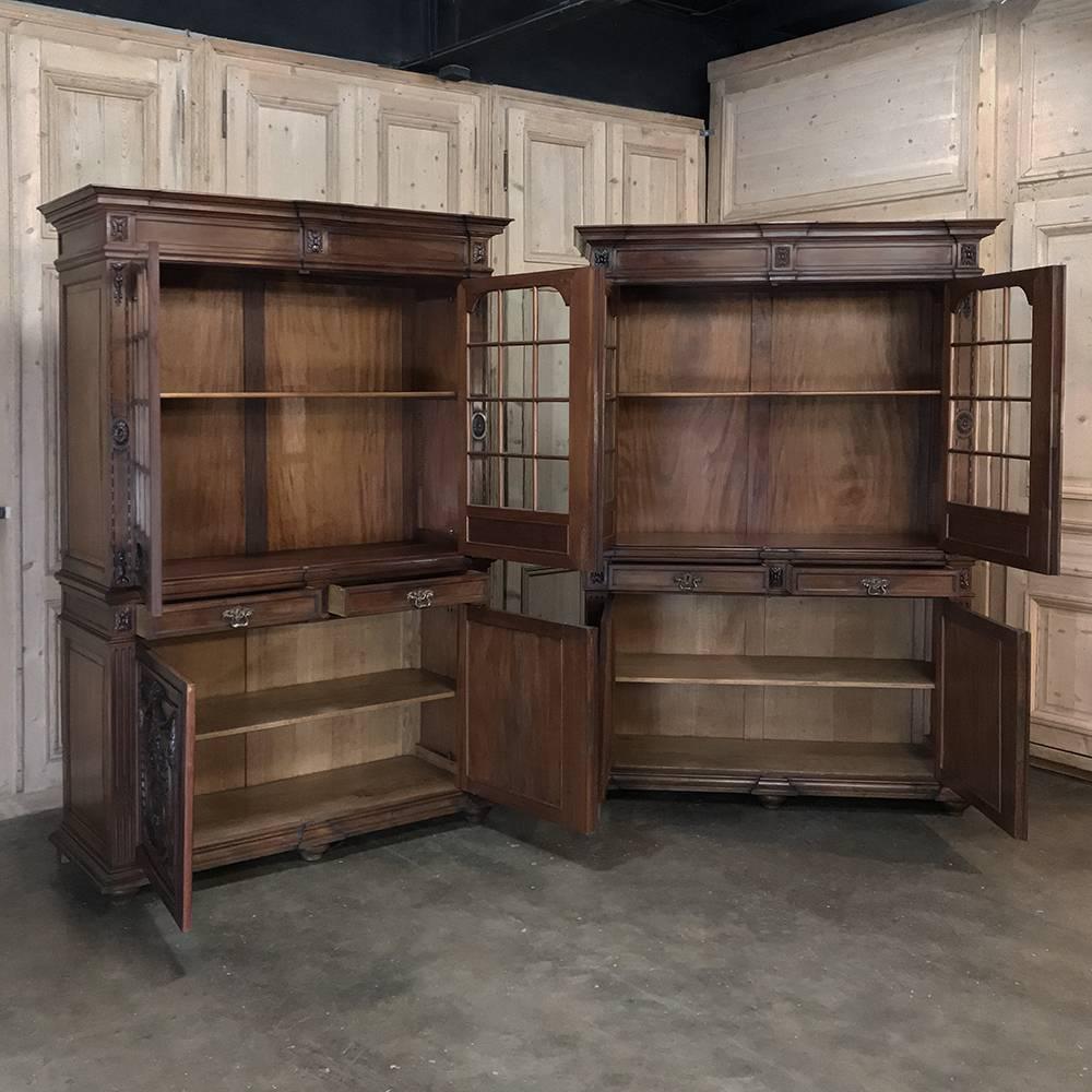 Pair of 19th century Louis XVI French walnut bookcases are truly rare, and exceptionally beautiful to behold! Exquisite floral, wreath, swag and foliate carvings abound, primarily on the lower door panels, with 24 glazed panes on each bookcase on