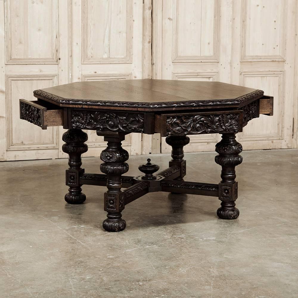 Exquisitely hand-carved from solid oak, this amazing antique Renaissance Revival game table features eight beautifully carved apron, four of which are drawer fronts! Supported by four amazing columns carved to depict urns, all resting atop a large,