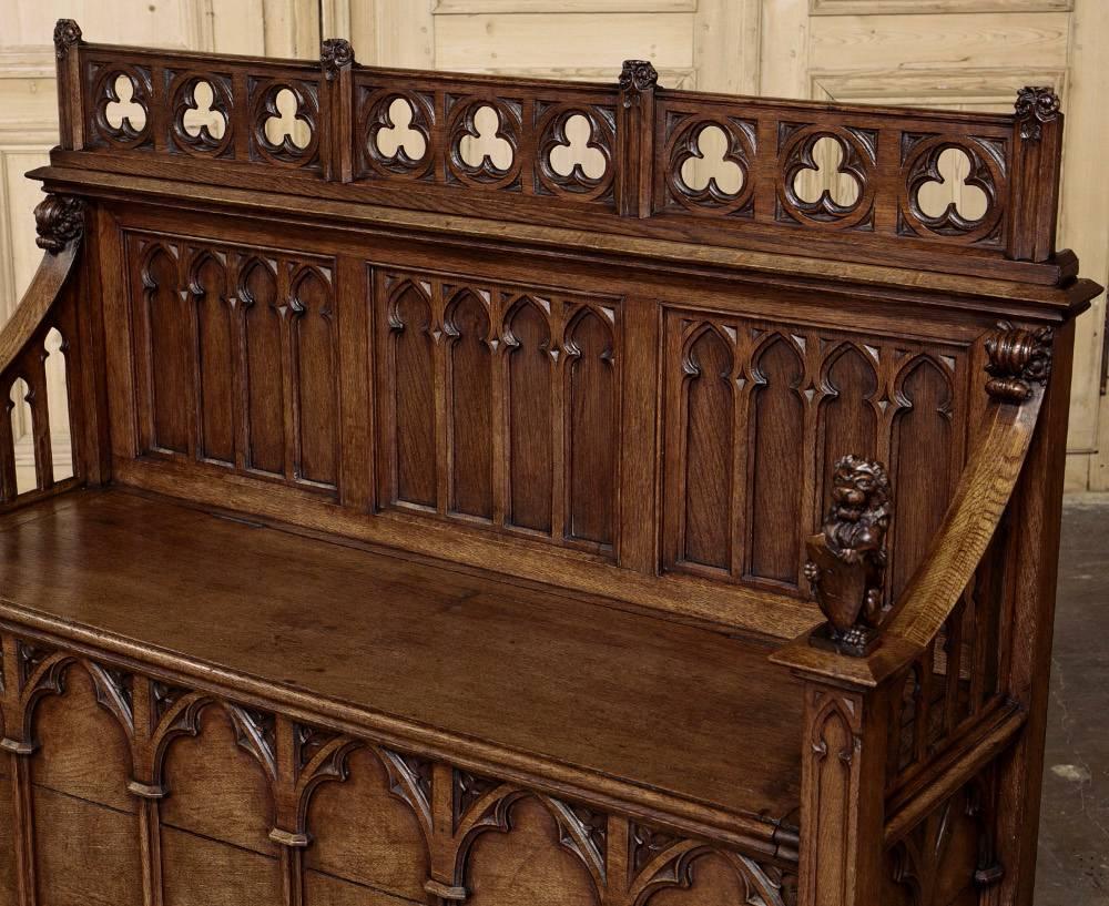 19th century French Gothic Revival hall bench features trefoils, Moorish arches and lions guarding the armrests!  Hand-carved from dense, old-growth French white oak to last for centuries.
circa 1850s.
Measures: 41.5 H x 51 W x 17 D.

Inessa