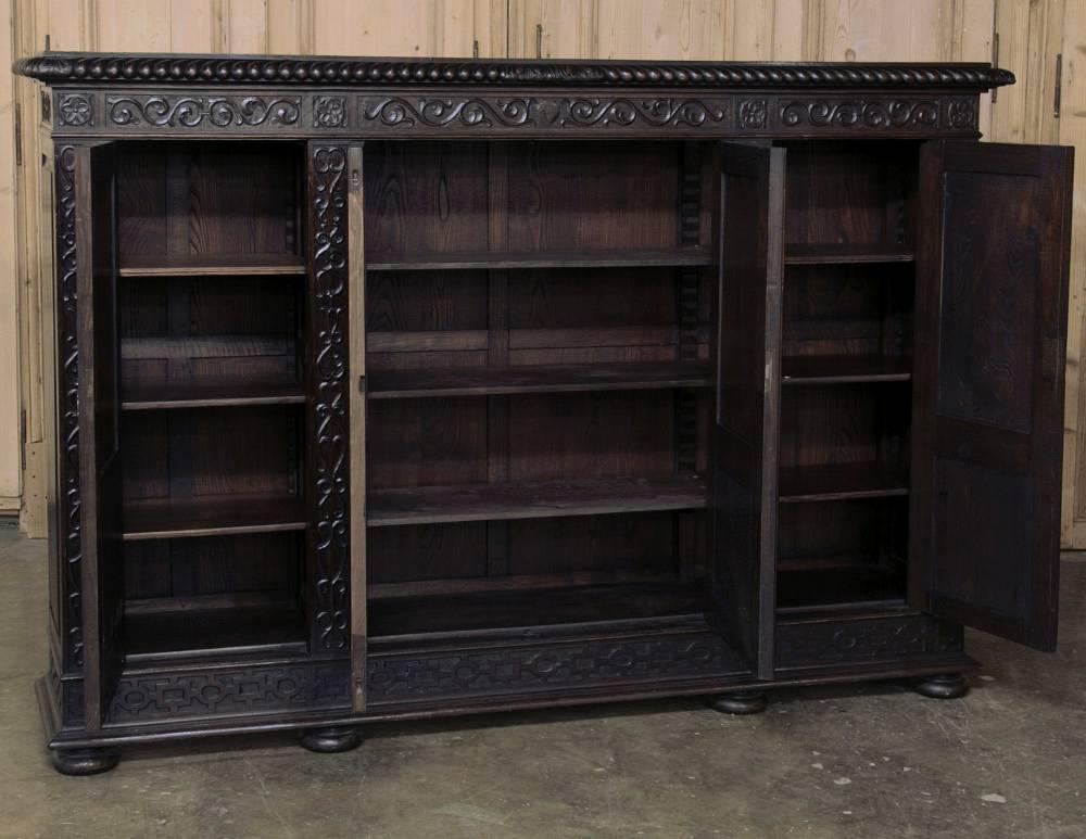 This 19th century Italian Renaissance armoire ~ bookcase boasts abundant hand-carved detail across the entire four door facade!  Hand-crafted from fine Italian walnut for generations of enjoyment!
circa 1890s.
Measures: 59 H x 86 W x 17