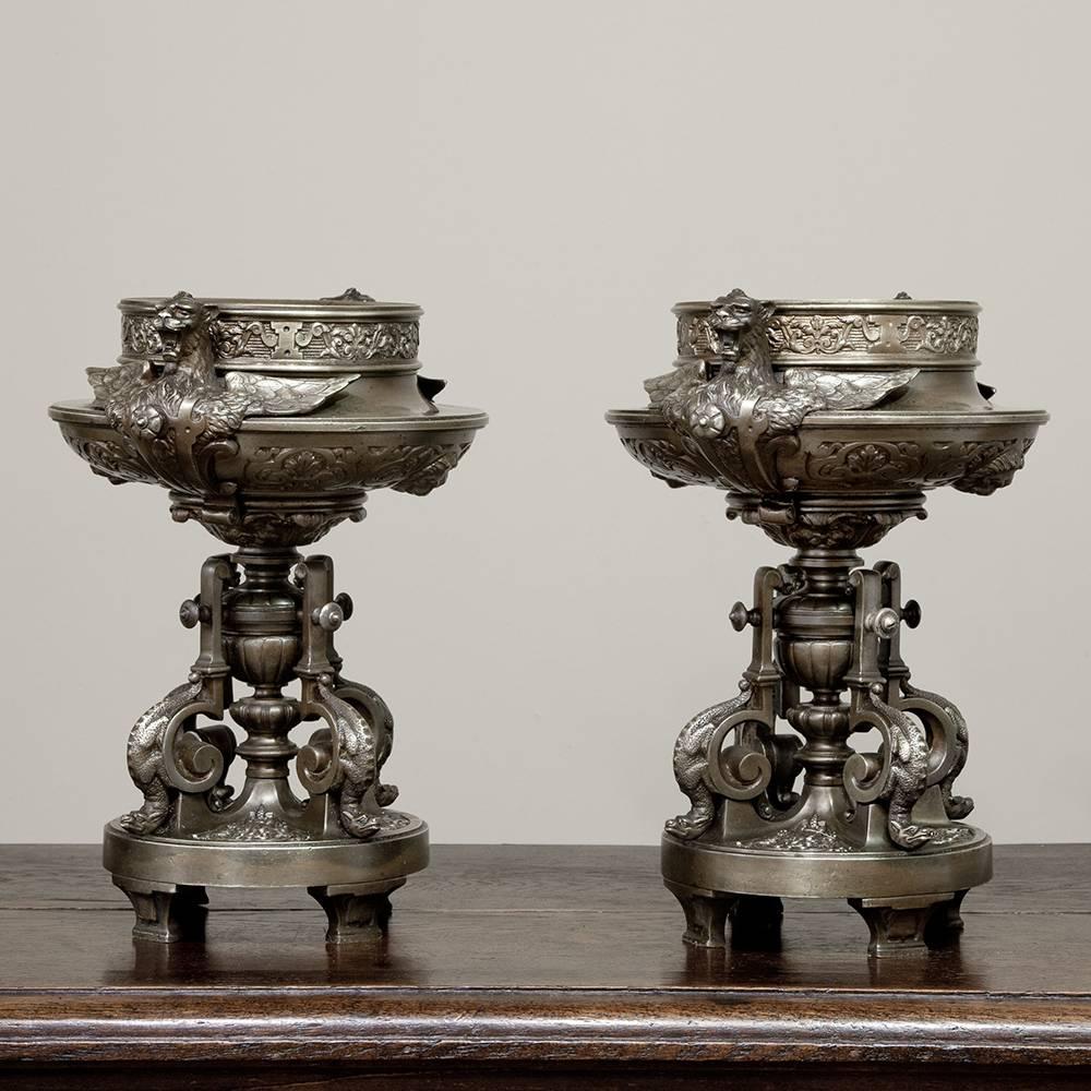Exuding a spectacular detail that was a result of some of the finest metalsmiths of France in the latter half of the 19th century, this pair of 19th century bronze mantel Urns feature elaborate bases and amazing artistry surrounding the bowl, with a