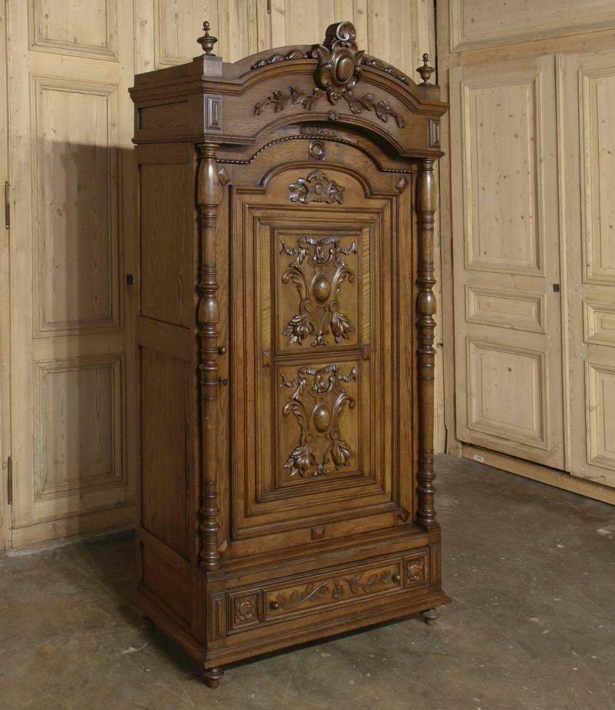 This stunning 19th century French Renaissance walnut armoire ~ crafted during the Napoleon III period ~ features two carved door panels instead of the more typical mirrors ~ with cornerposts adorned with intricately turned columns. Arched crown