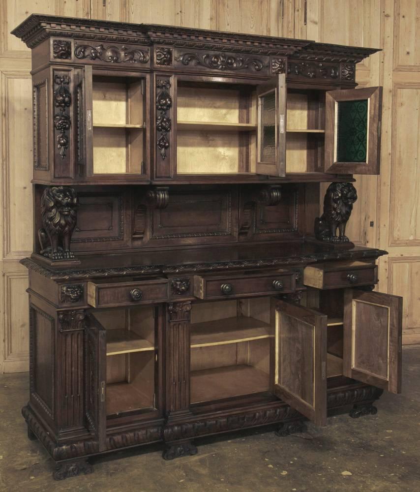 Lavished with Romanesque architecture and hand-carved Renaissance-inspired detail, this 19th century Italian two-tiered buffet features gilded wrought iron overlays on green glass above, with the upper tier held aloft by carved seated lions!
circa