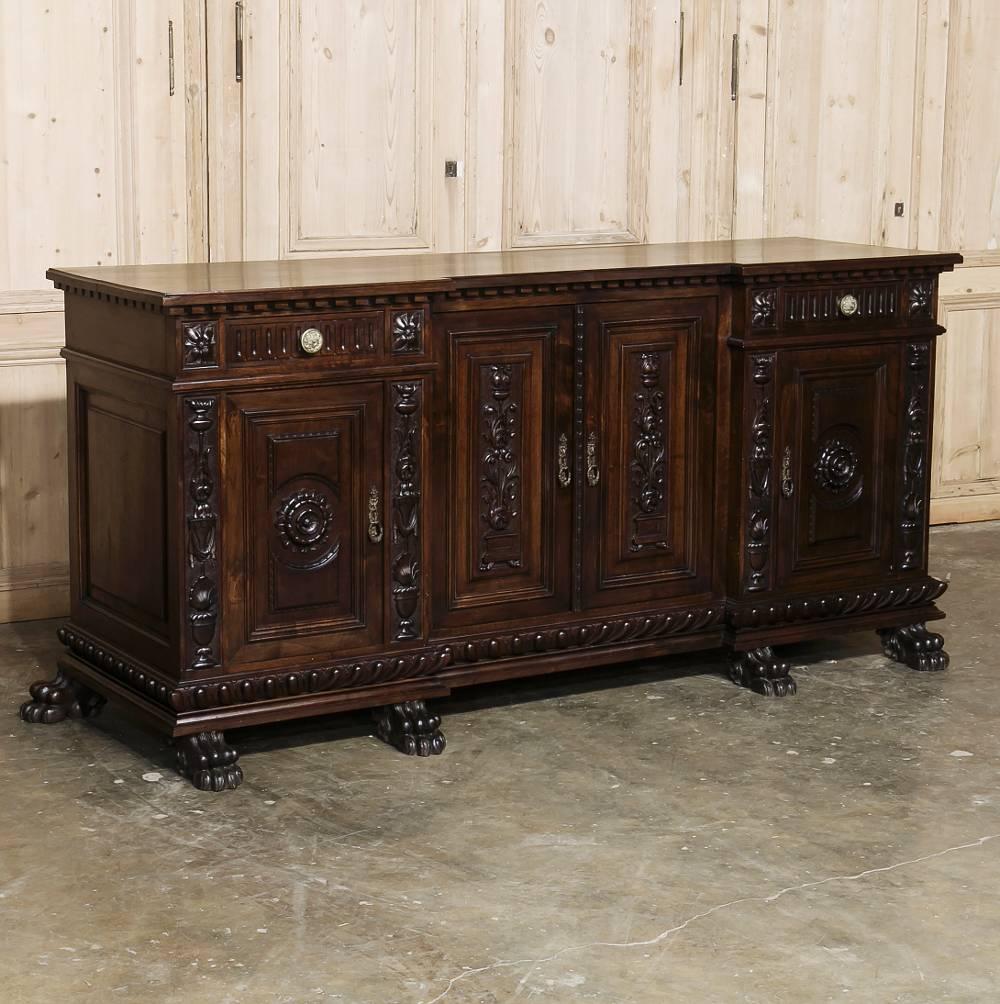 Sculpted from fine Italian walnut, this splendid antique Italian Renaissance buffet features beautifully carved chamfered panels ~ and the lower of which features an intriguing step-back center section, enhanced by the elaborate hand-carved panels