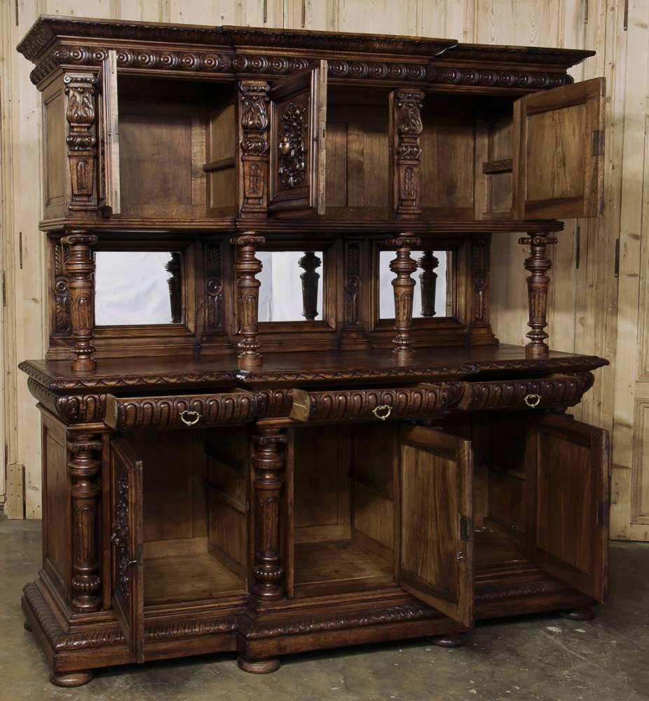 19th century Italian Renaissance walnut two-tiered buffet features turned and carved columns framing the mirrored backsplash and carved cabinet doors below,
circa 1870s.
Measures: 89.5 H x 88 W x 28.5 D ~ surface 39.5 H.
