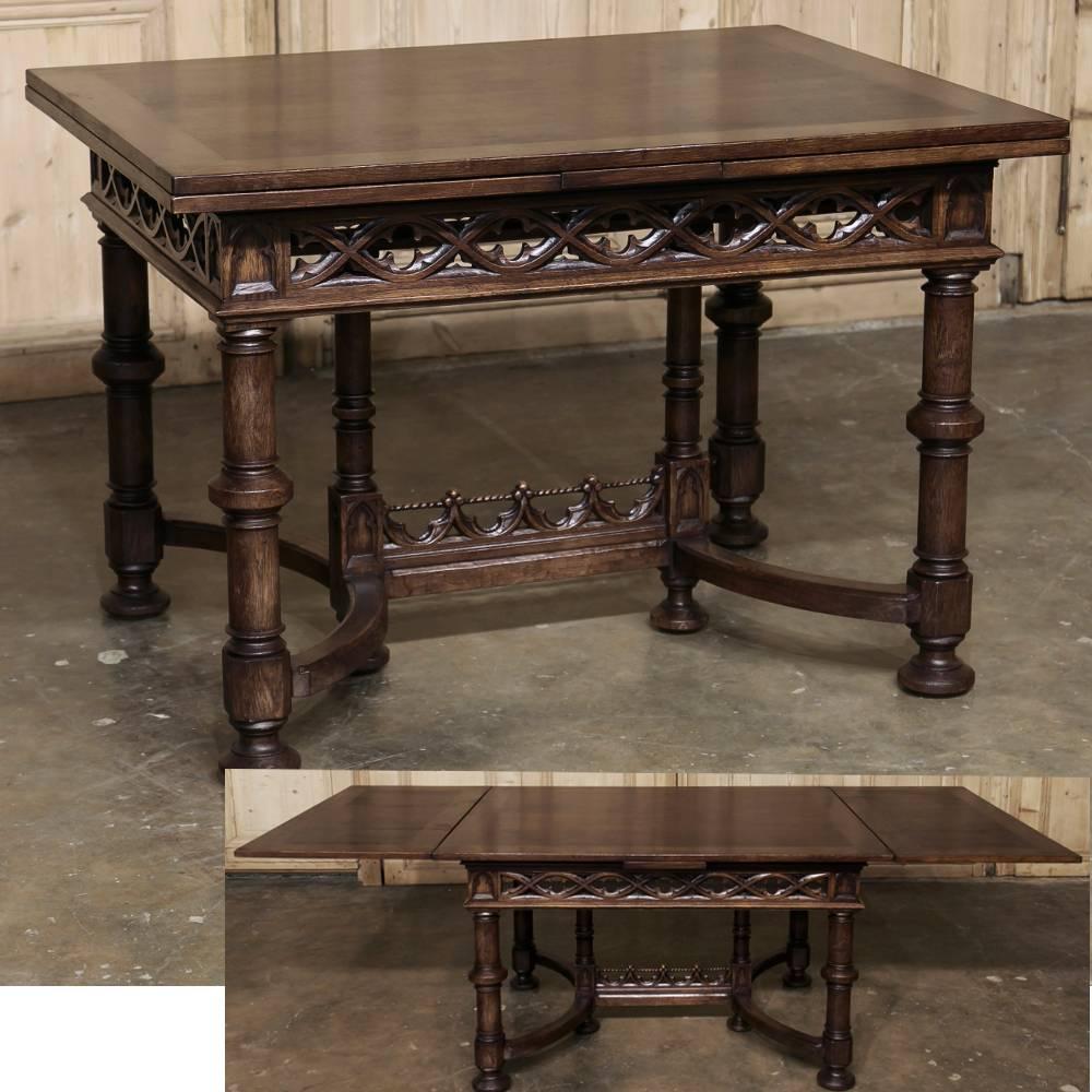 19th century French Gothic draw-leaf dining table was meticulously handcrafted from old growth French oak, and combines timeless styling with the convenience of leaves that draw out in an instant when needed, then just as quickly tuck back in to
