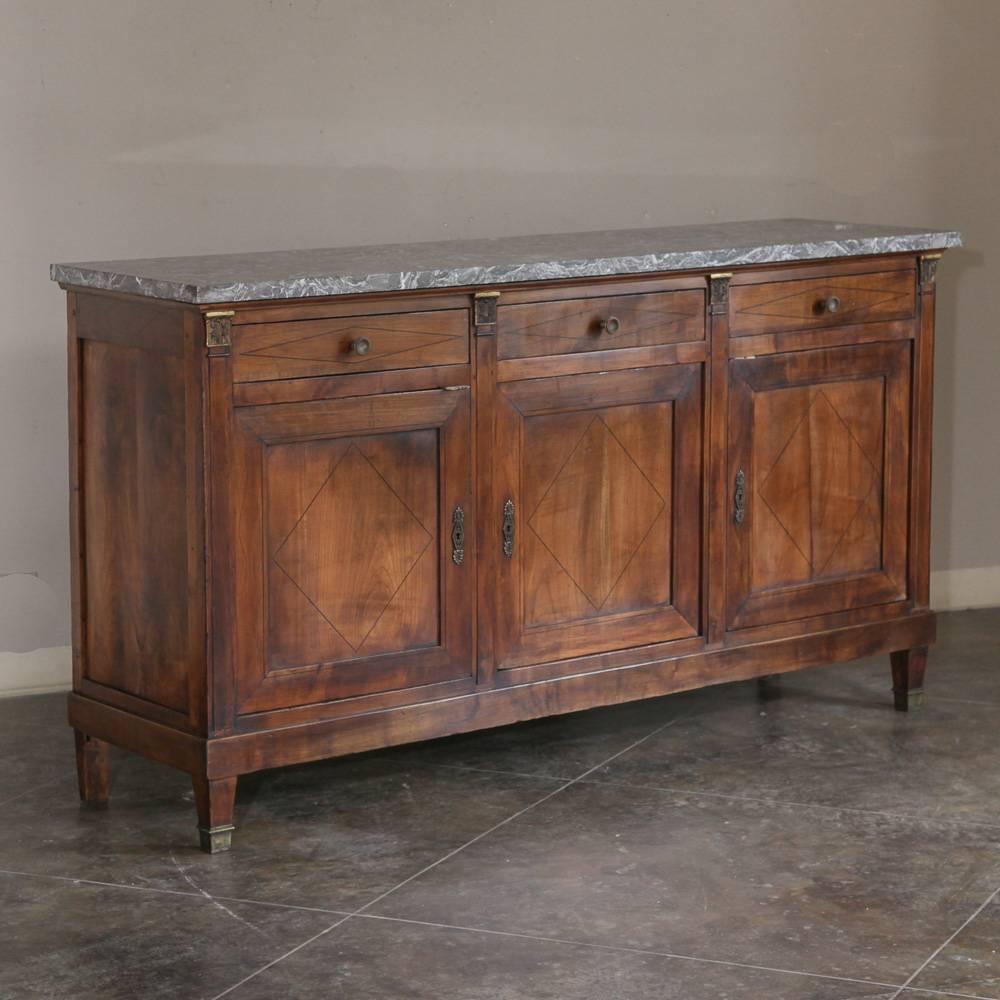French Empire walnut grey marble-top buffet decorated with refined diamond shaped wood inlay. Foliate bronze ormolu and original bronze gilded hardware herald Egyptian, Greek and Roman motifs characteristic of this early 19th century style. Perfect