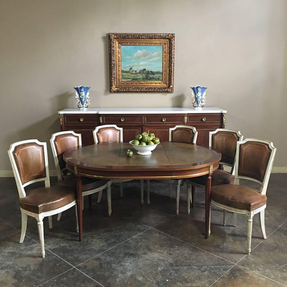 This set of six 19th century French neoclassical leather chairs will add tailored elegance, comfort, and style to your dining experience! The rich original brown leather backs and seats are accented with beautiful floral gilded accents and finished