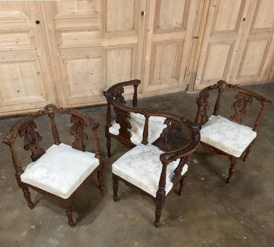 Sculpted from solid Italian walnut, this Pair of exquisite 19th century Italian Renaissance corner chairs were designed to accompany the adjacent courtship chair and were also designed to be placed towards the center of the room (in close proximity