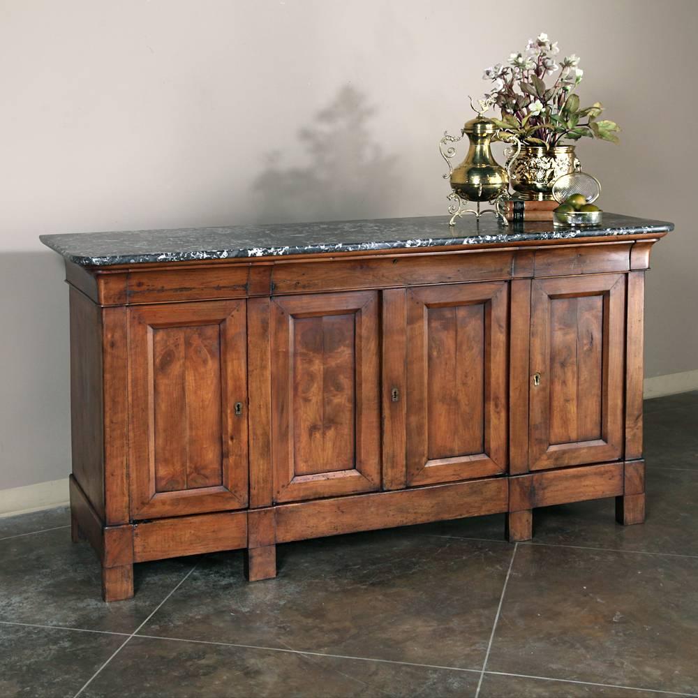 Completely handcrafted during the Louis Philippe Period, this exceptional Marble Top Buffet was fashioned by talented artisans from solid cherrywood, then topped with luxurious marble for a splendid piece of antique furniture that offers carefree