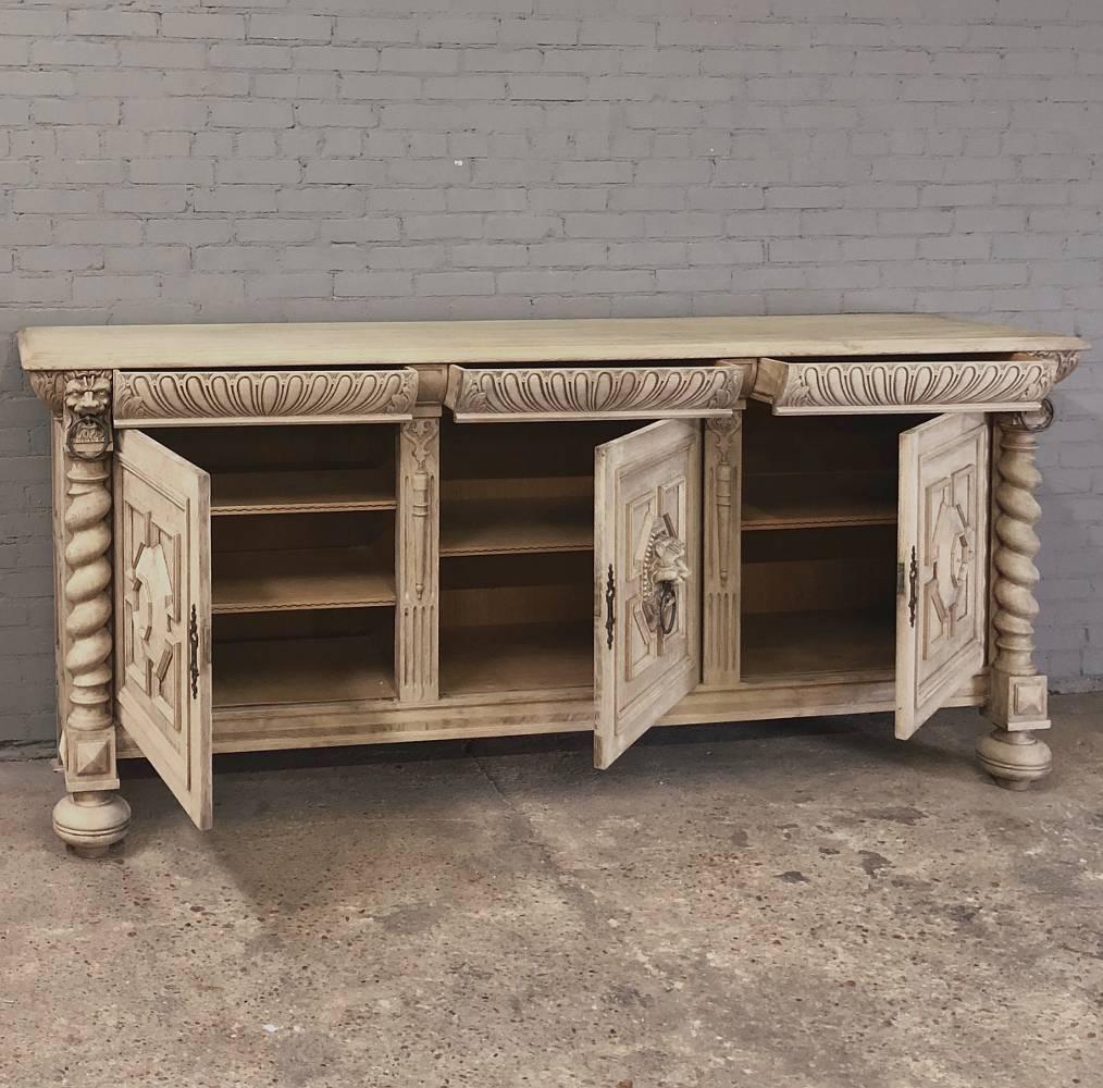 19th Century Grand Renaissance Stripped Oak Buffet measures a full eight feet in width and features a timeless hand-carved facade which includes decorative molding and barley twist columns surrounding the three primary door panels, the centre of
