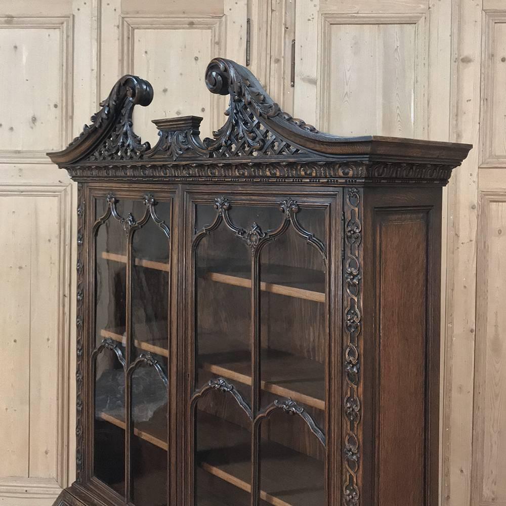 19th century English Georgian secretary or bookcase is a magnificent example of the genre, with elaborately carved facing arches and latticework creating a regal crown atop the glazed upper tier. Arched muntions separate the hand-rolled glass panes,