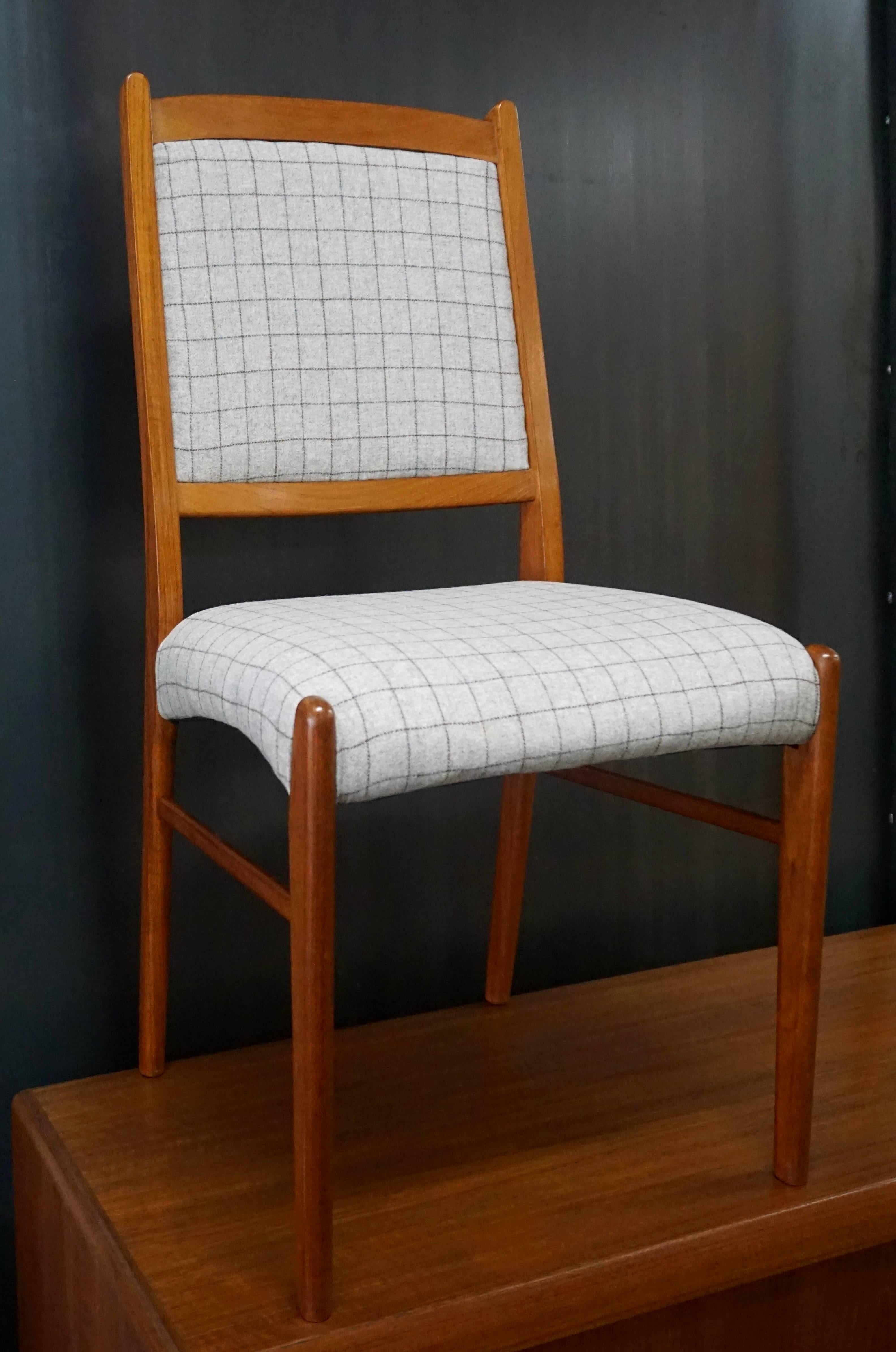 Two armchairs and six side chairs in this set. Made in Denmark. Teak frames, freshly oiled. New wool blend fabric from Greenhouse Fabrics (B6297 Vapor). Very nice, clean set. Armchairs measure: 22.5 in. W x 18.5 in. D x 36.5 in. H.