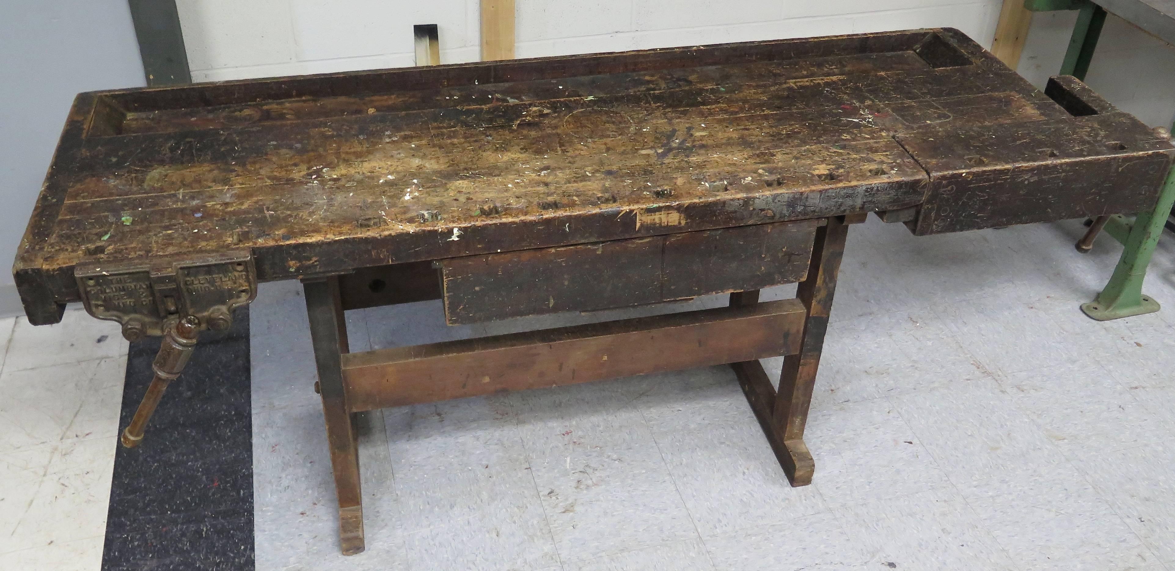 Great original patina work bench. Covered with paint , dirt and scuffs. The piece has not been cleaned, but is very usable with no oils on the surface.The piece comes with 3 metal dogs.The side vise is signed. Nice drawer under work surface..Some