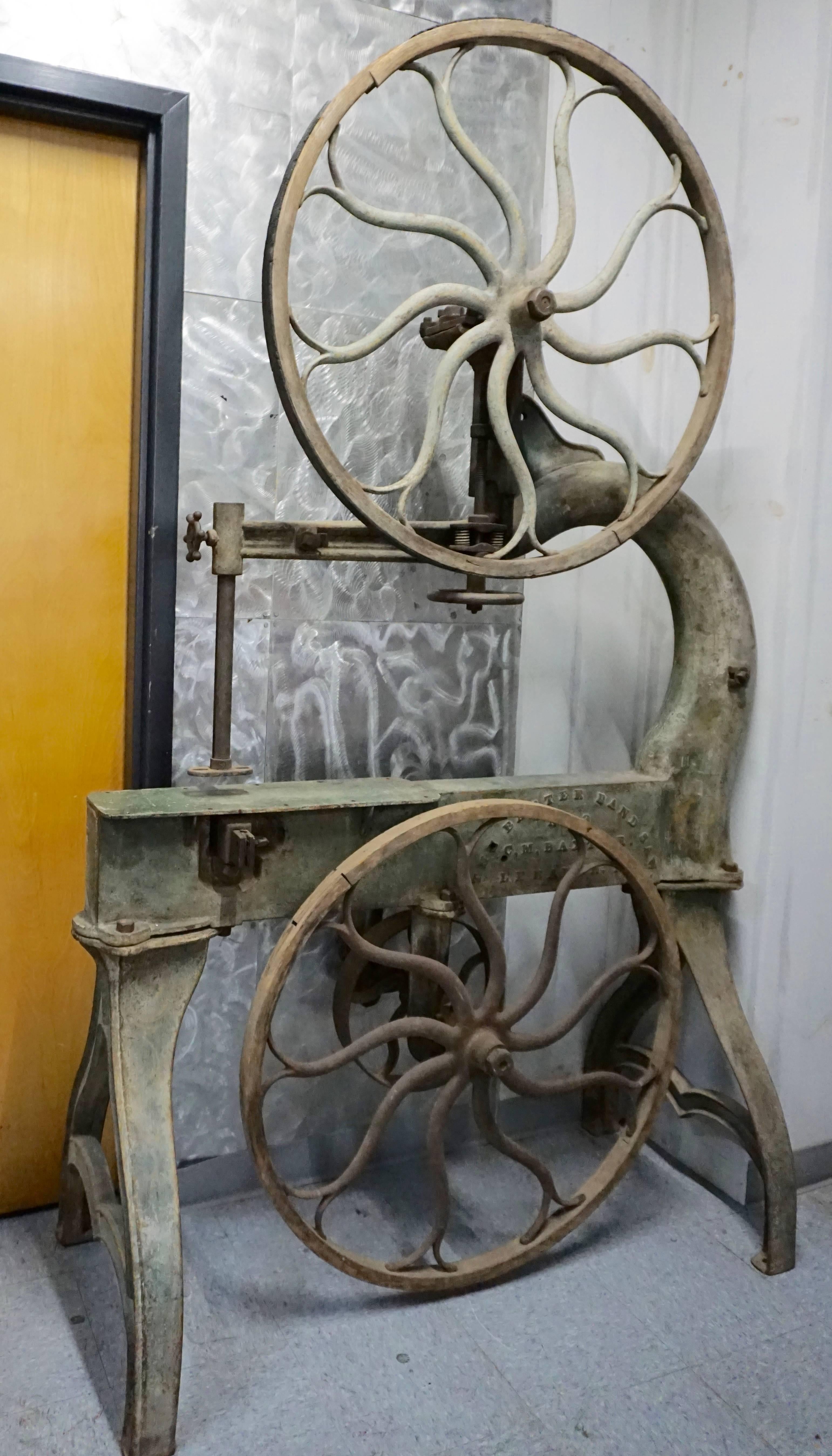 Belt driven saw. Cast iron, with wood around wheels. All original paint with some fancy painted details. Weighs about 800 pounds, but does come apart. Could make a great dry bar by adding wood platform. Wheels are 35.5 inches wide.