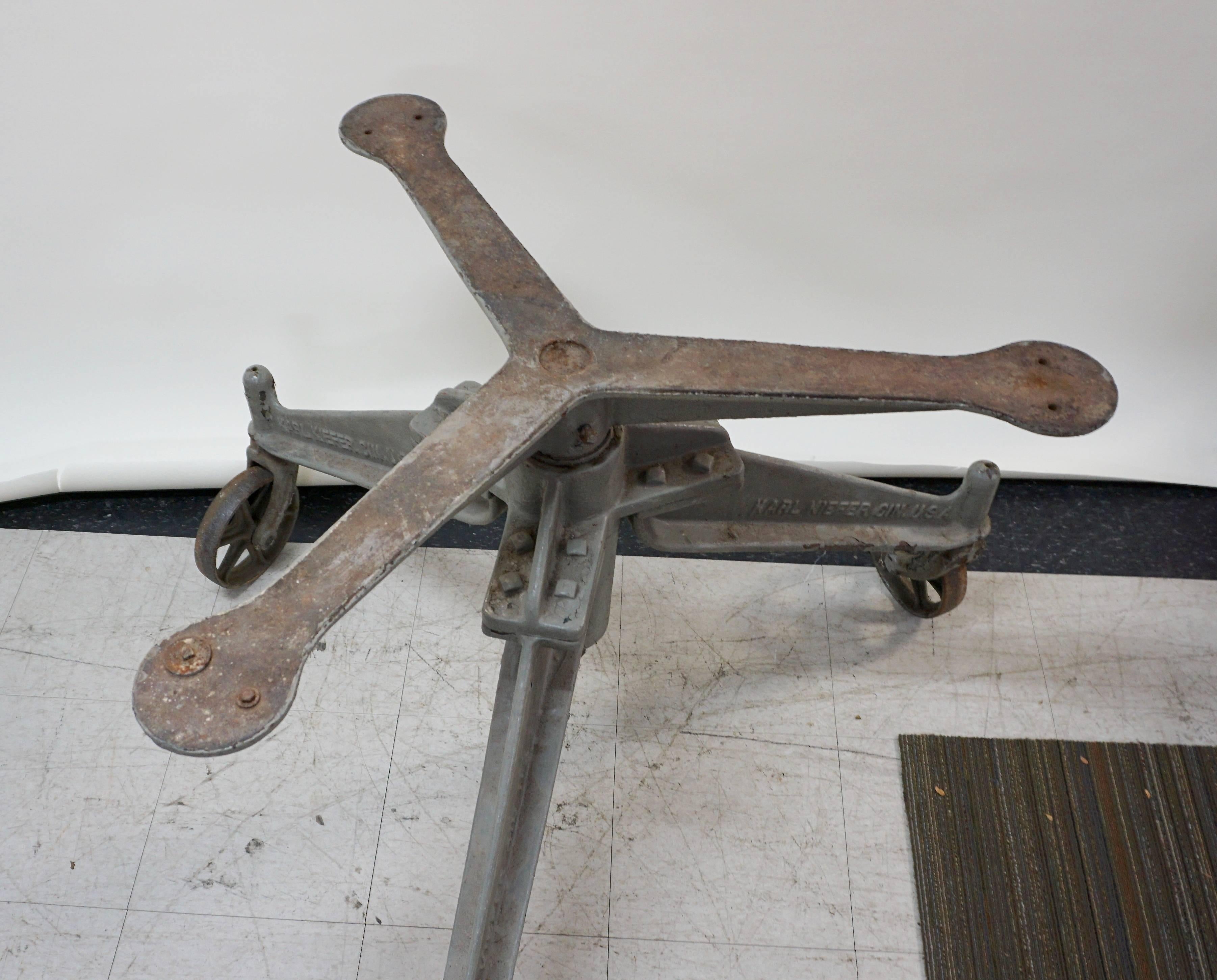 Originally used in a bottling plant, this would make a great table base. Very large. Cast iron with steel wheels. Spinning arm support on top. Unrestored, it is in excellent condition. Some chipping paint and rust, but incredibly sturdy. Could be