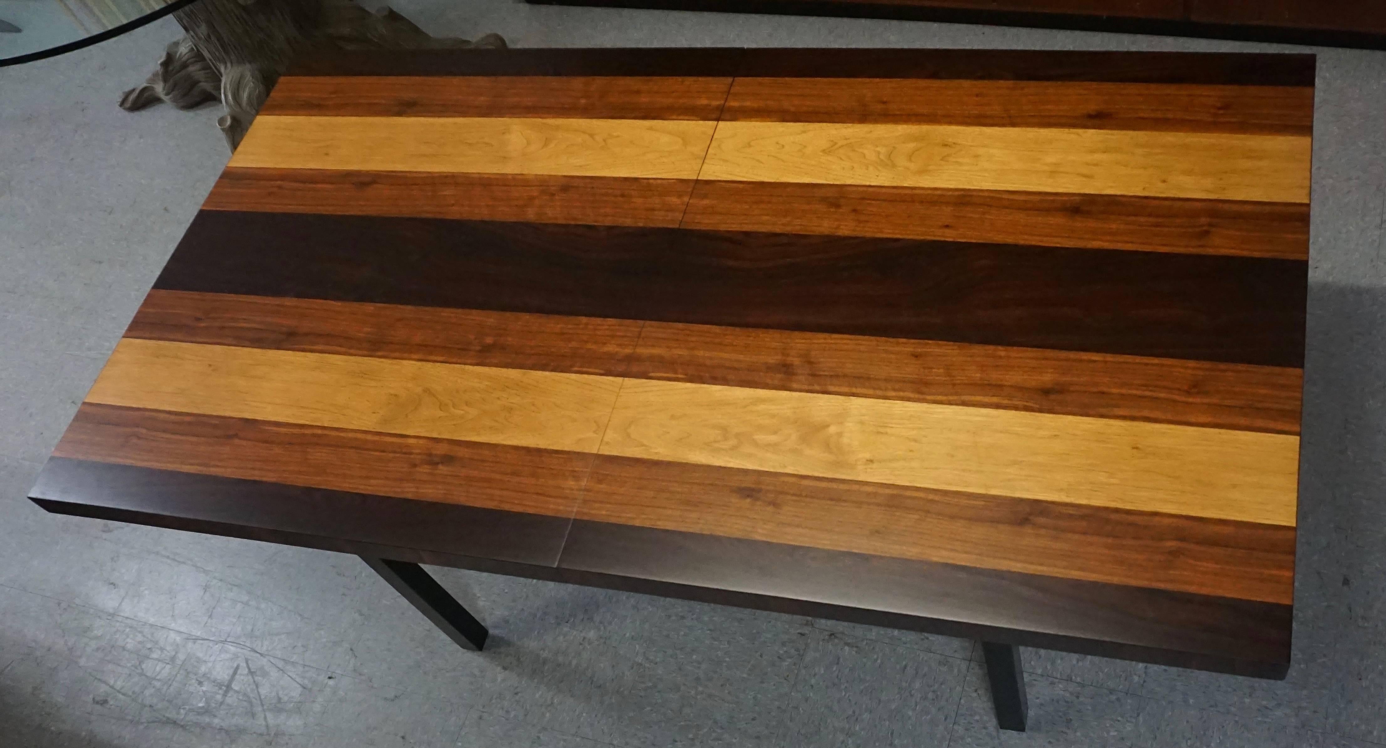 Restored. This table has very strong and bright veneer colors. New black lacquer on the legs. There are a few marks underneath new surface, but not very noticeable. One center leaf measures 20 inches, which makes the table a total of 90 inches long