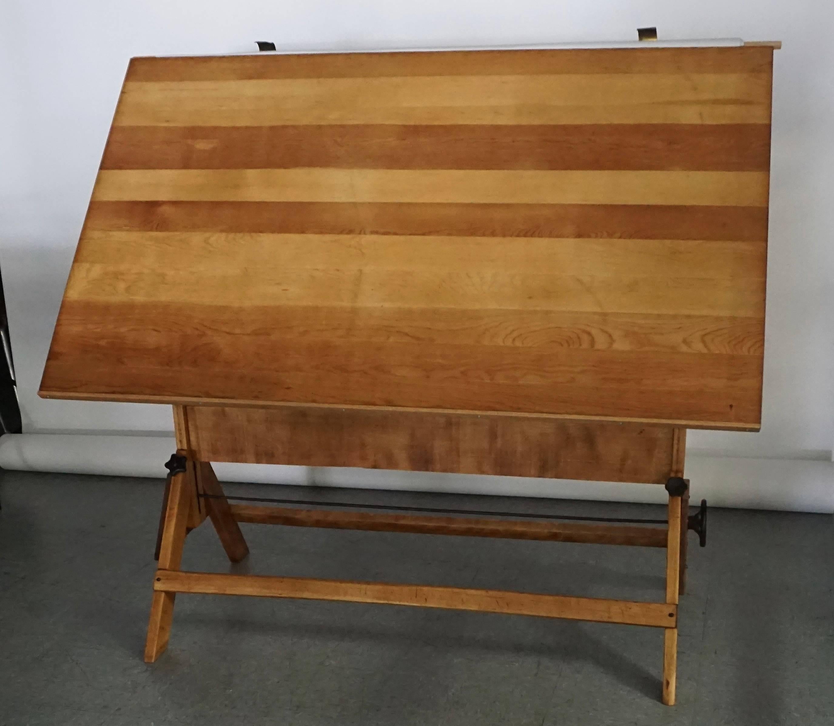 All refinished maple wood with a grey-blue oil cloth cover. Brass holders at top to hold rolled cloth. Cast iron moving parts with the exception of one replaced handle near the base, which is plastic. Operates smoothly. Top surface has scuffs and