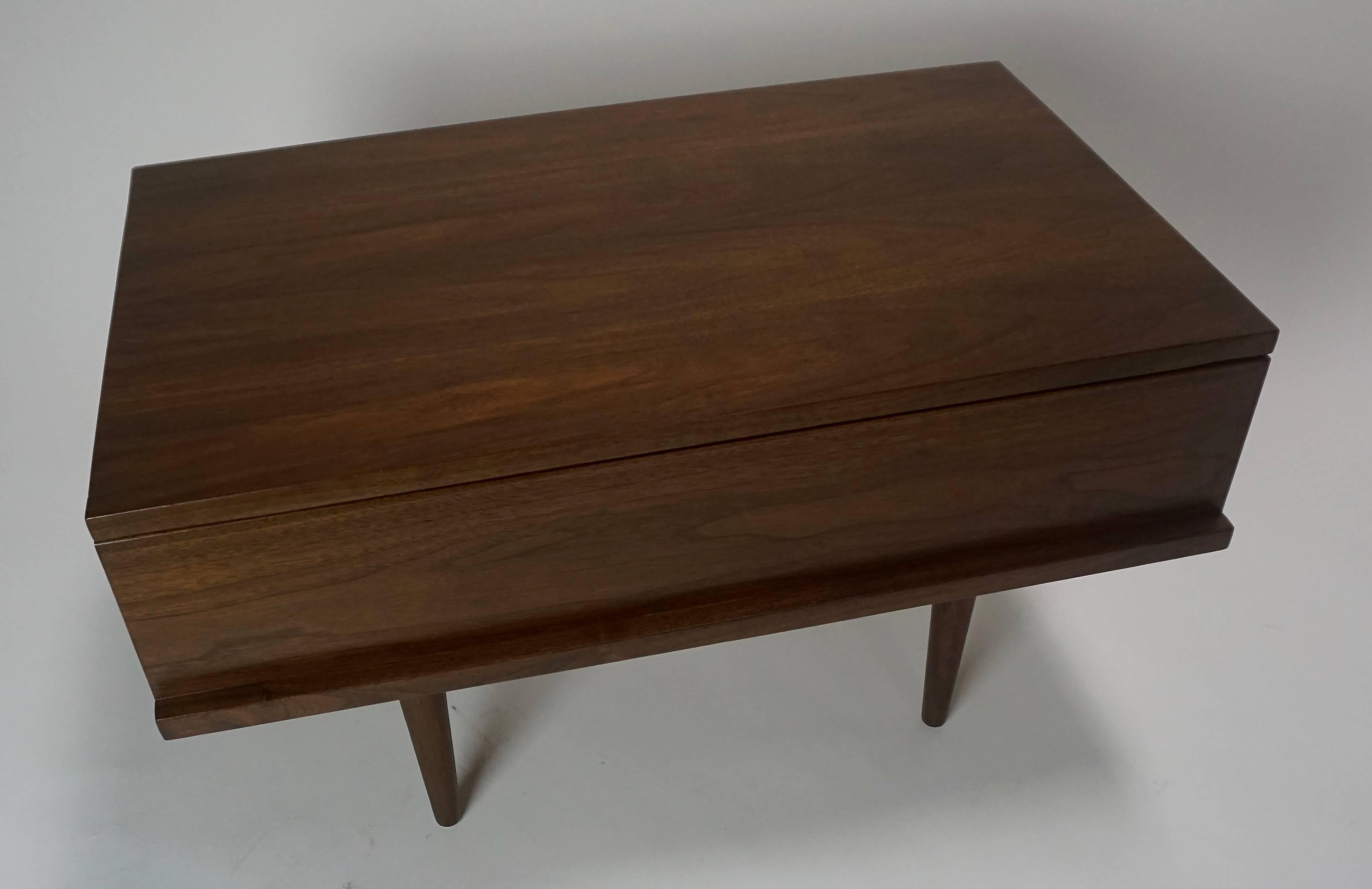 Made in NYC. Walnut with single drawer. Restored. Very simple construction. Just a few small dark scuffs under the finish.