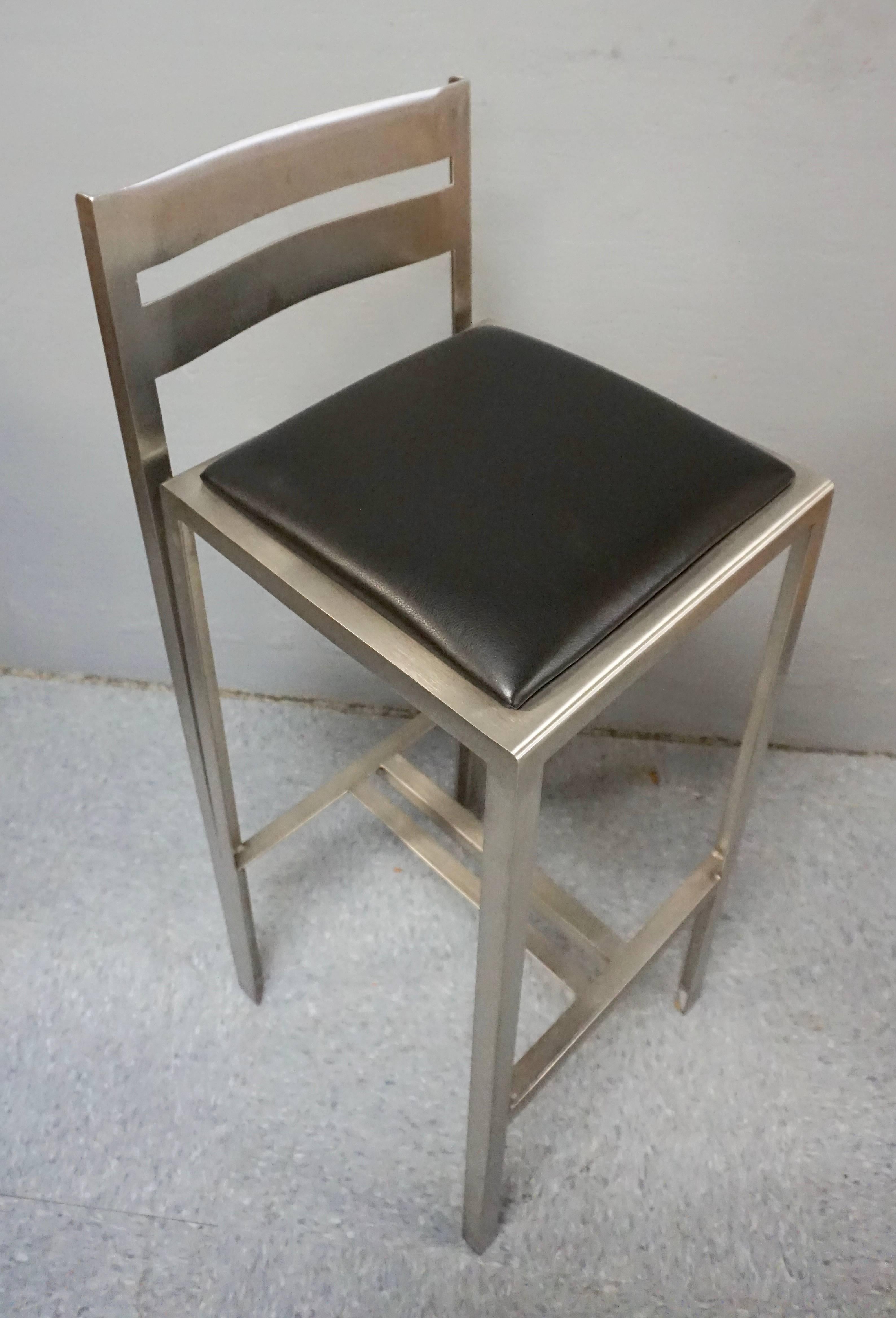 Brushed stainless steel with black leather seats. No rips or tears in the leather. Nice heavy construction. The back is 9 inches high from the seat. There are no bolts or screws used, as all pieces are welded together. The way they are constructed
