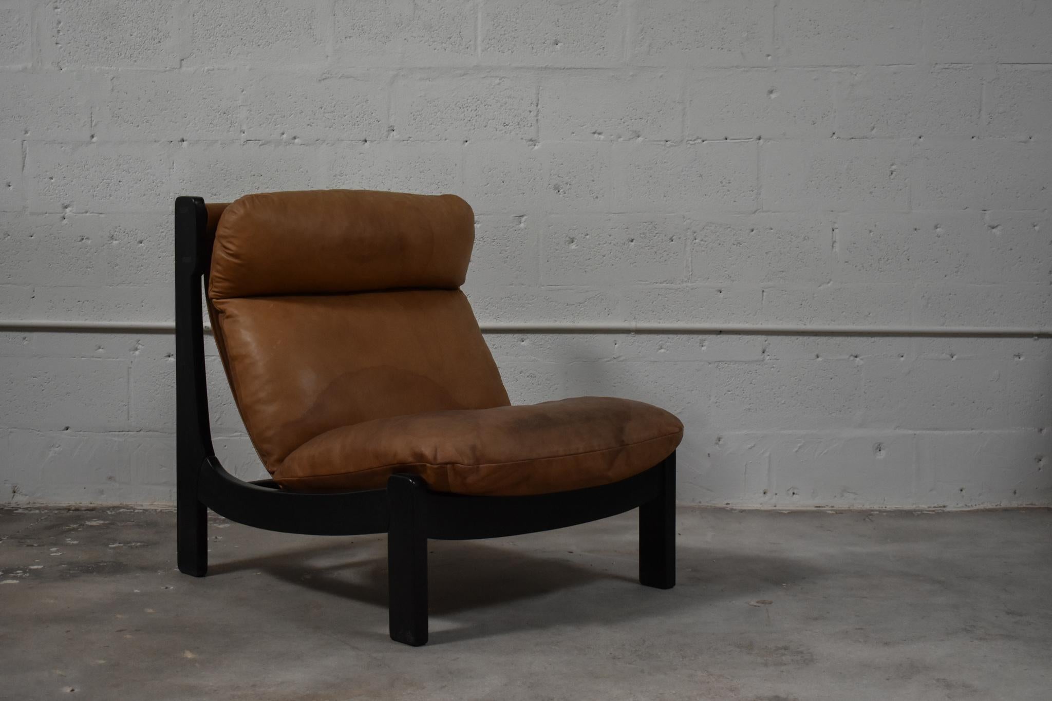 Chaise longue italienne basse des années 1970, présentant les lignes audacieuses et sculpturales et la sensibilité décontractée de l'époque. Doté d'un cadre en bois ébonisé aux courbes prononcées, ce meuble offre un contraste saisissant avec ses