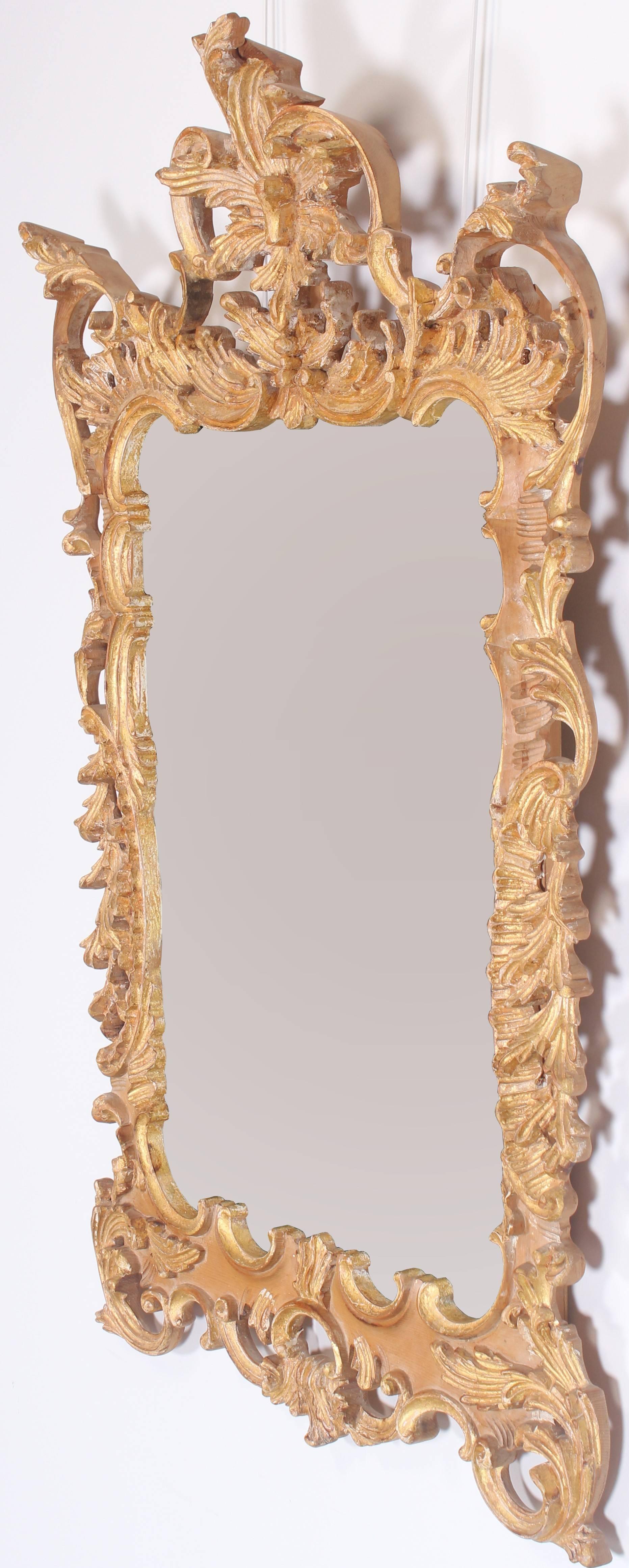A hand-carved frame made in Italy by Labarge. The highly carved frame has a nicely executed antique finish showing some natural wood, gesso, and gold gilt finish. There is one tight line in the wood on the left side of the cartouche, inherent to