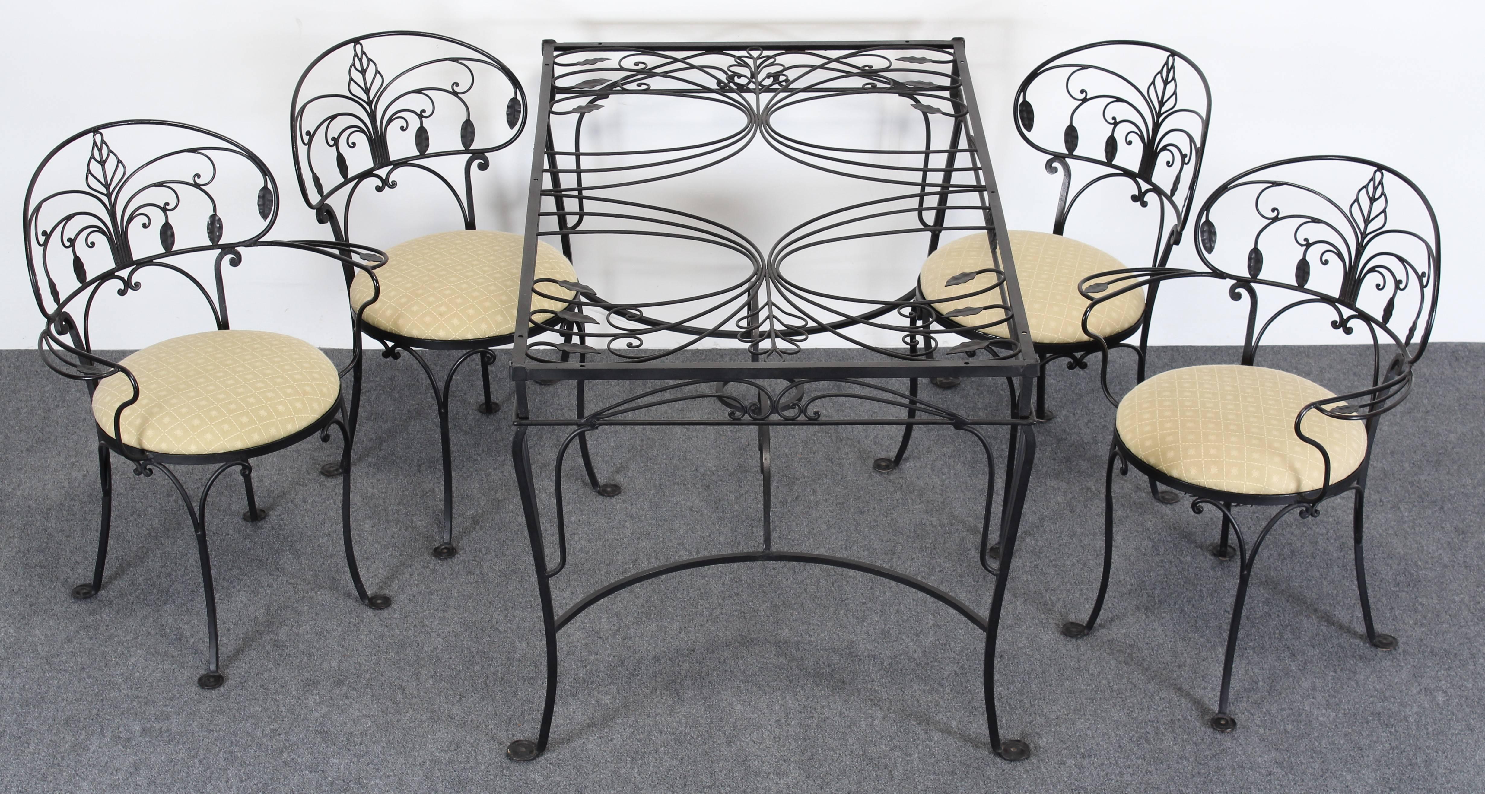 Vintage five-piece Salterini Florentine painted wrought iron dining set from the 1940s.
The set consists of two armchairs and two side chairs. The wrought iron rectangular dining table has an ornate leaf design. The Salterini set has the trademark