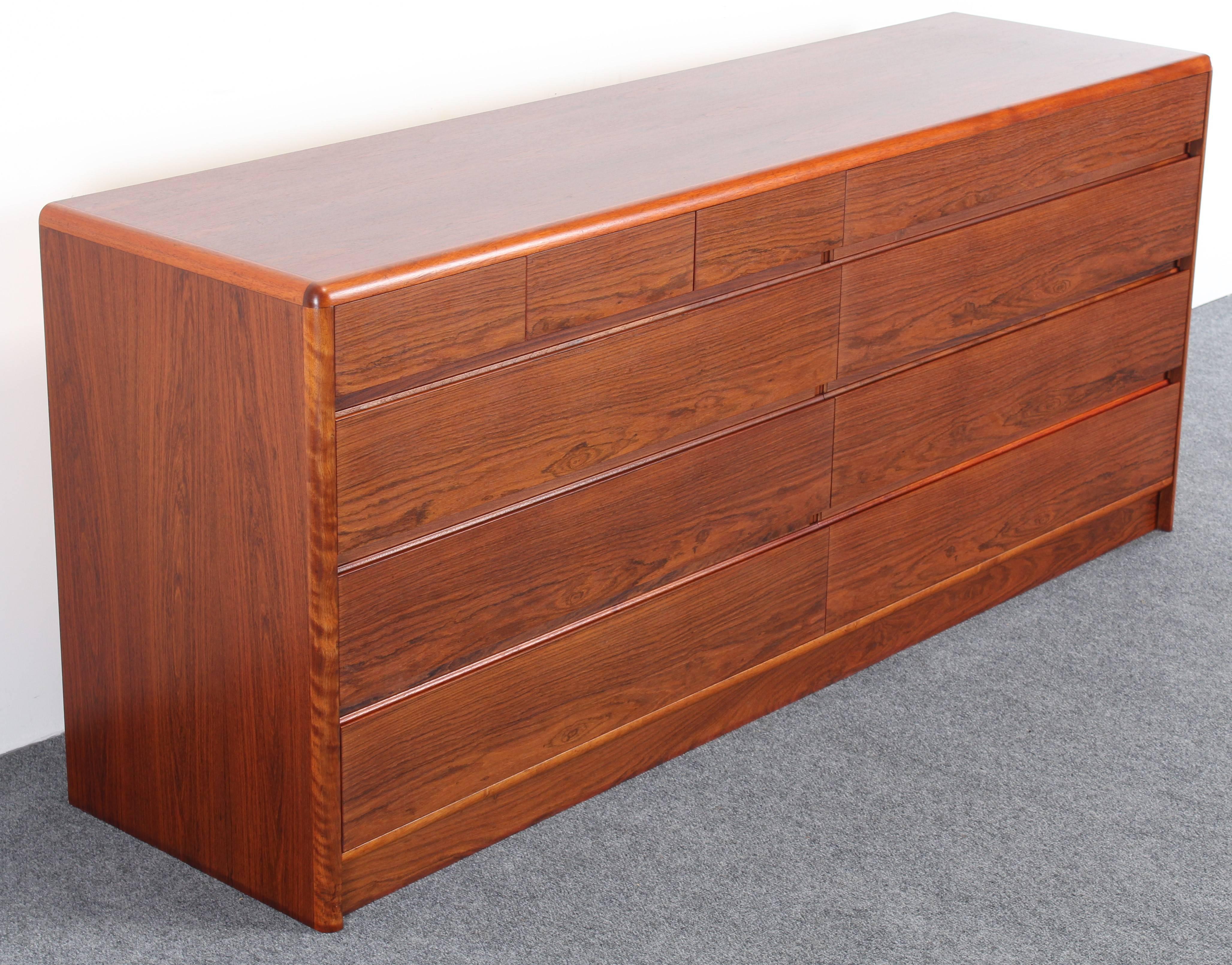 A stunning rosewood dresser with lots of storage for functionality with ten drawers. The gorgeous rosewood finish and simplicity of this piece makes a modernist statement.