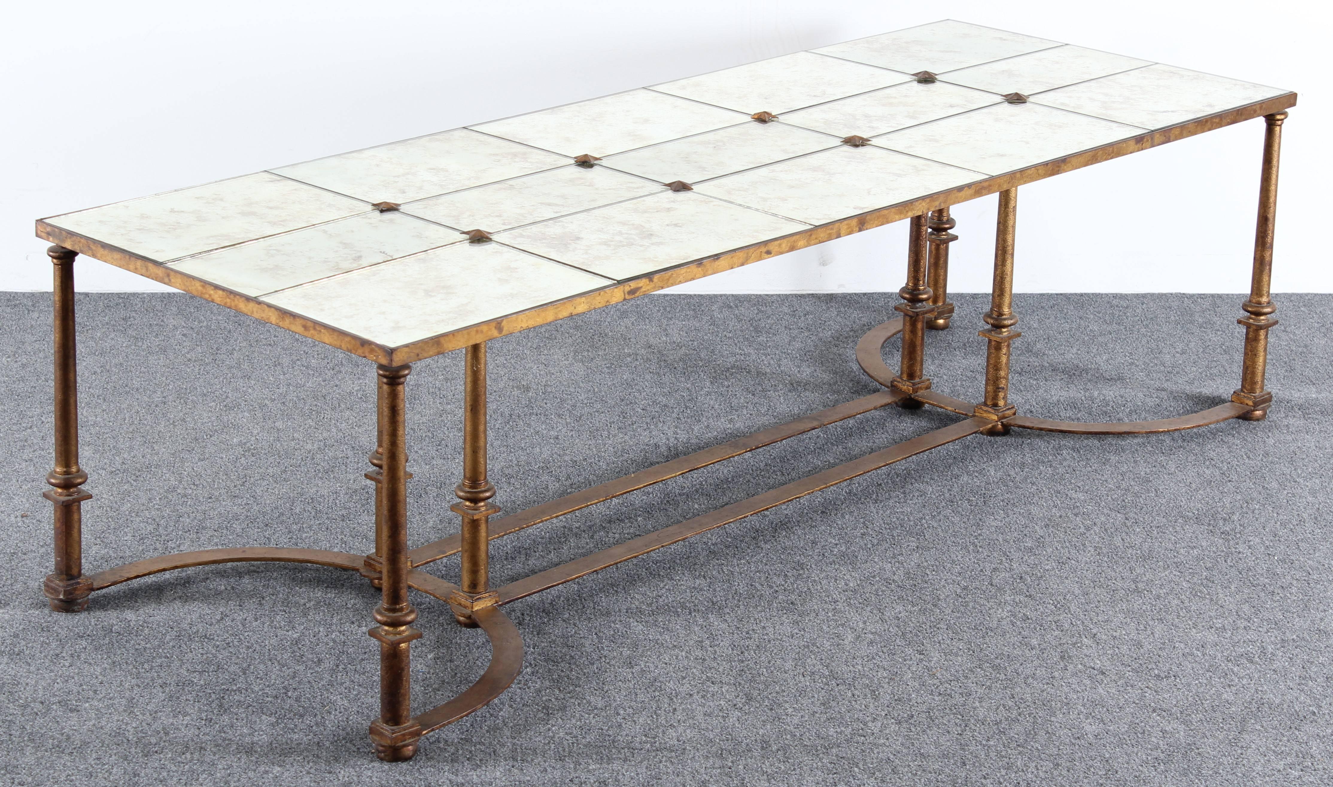 A stunning 1940s gilt wrought iron French coffee table in the style of Maison Baguès. Decorative panelled silvered églomisé top has mounted metal stars on surface.