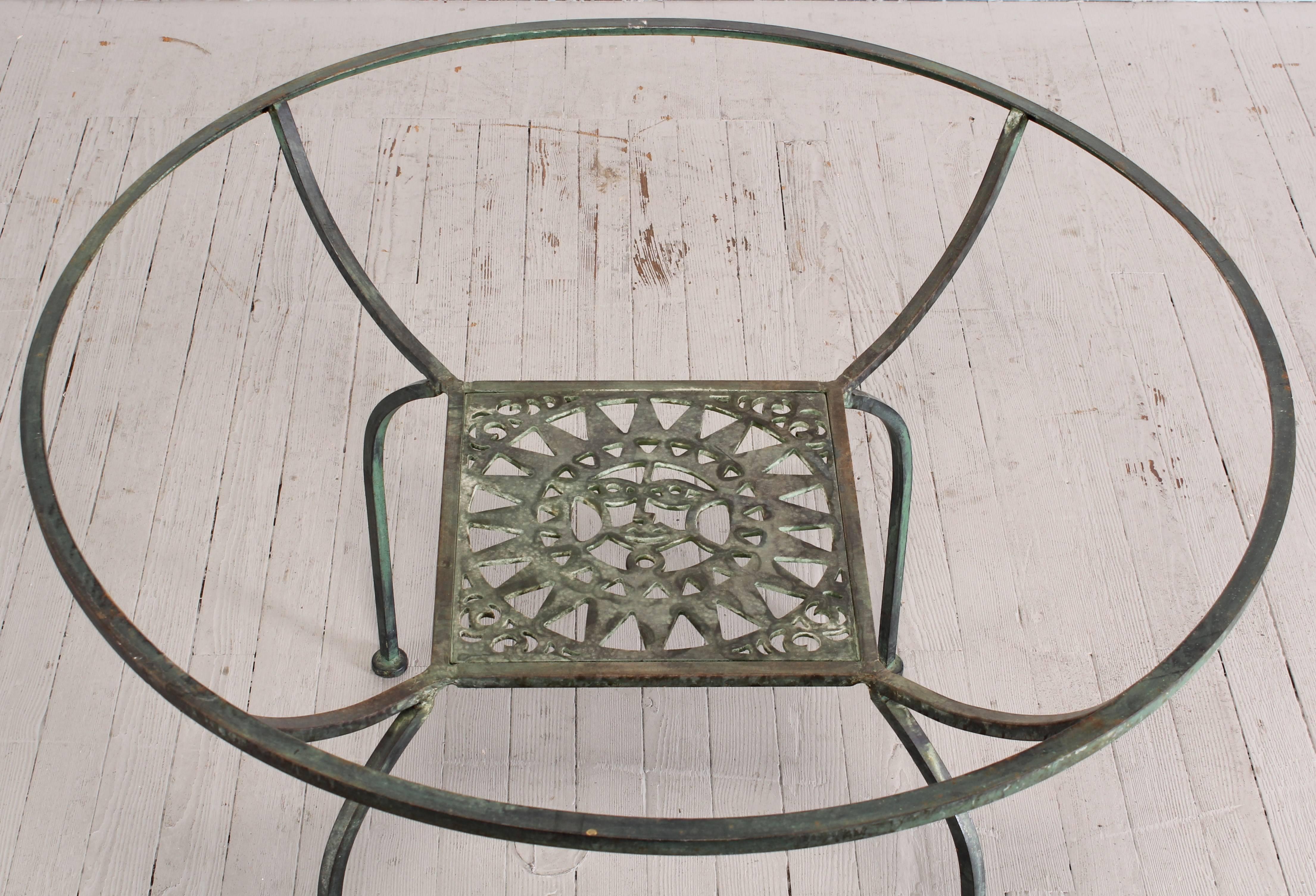 A beautiful painted verdigris seven-piece wrought iron patio set by Shaver-Howard, 1960. The chairs have a Greek key pattern motif and a sun face table. Dimension of chairs found below. Dimensions of table are 42